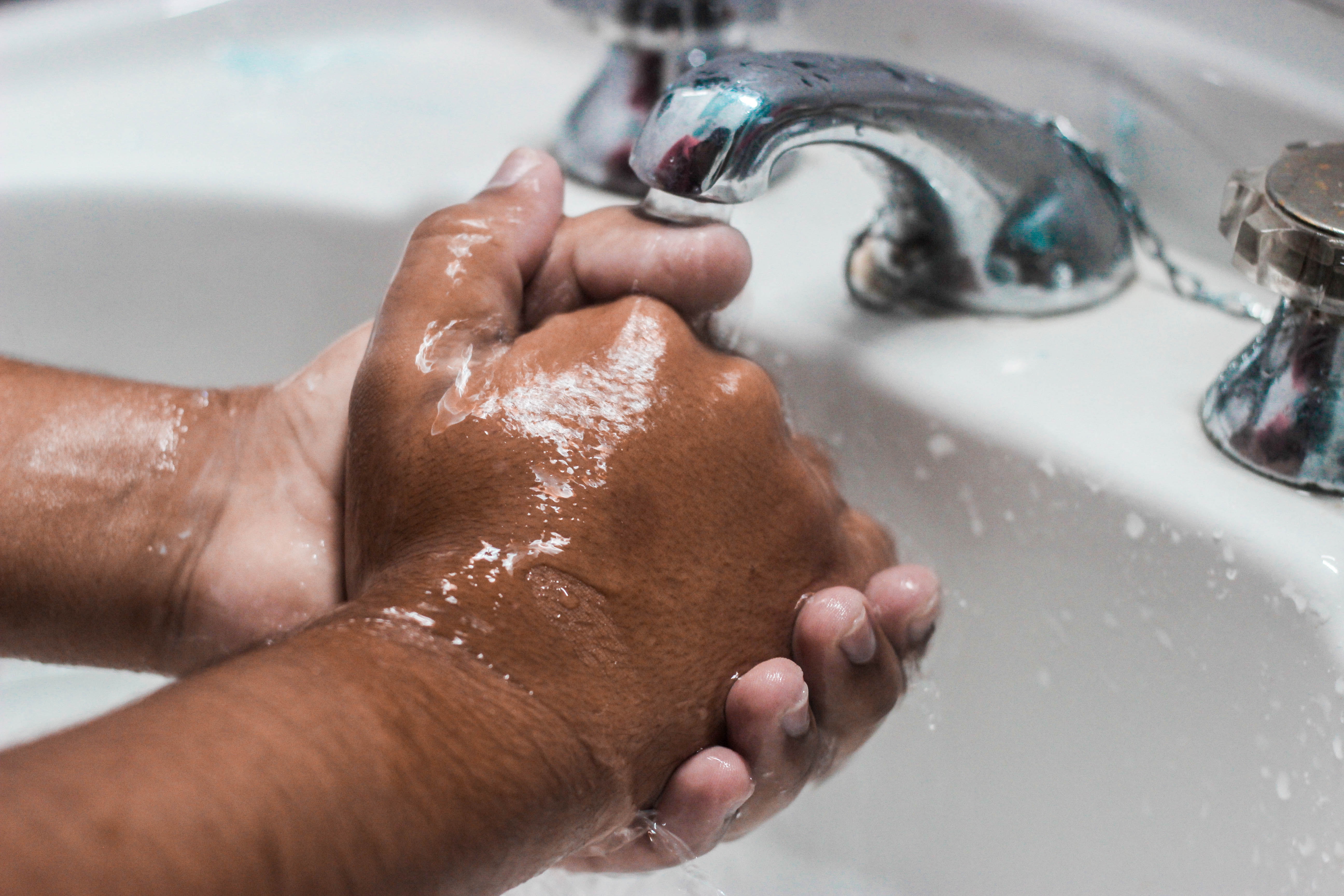 Washing hands prior to administering first aid treatment at home.