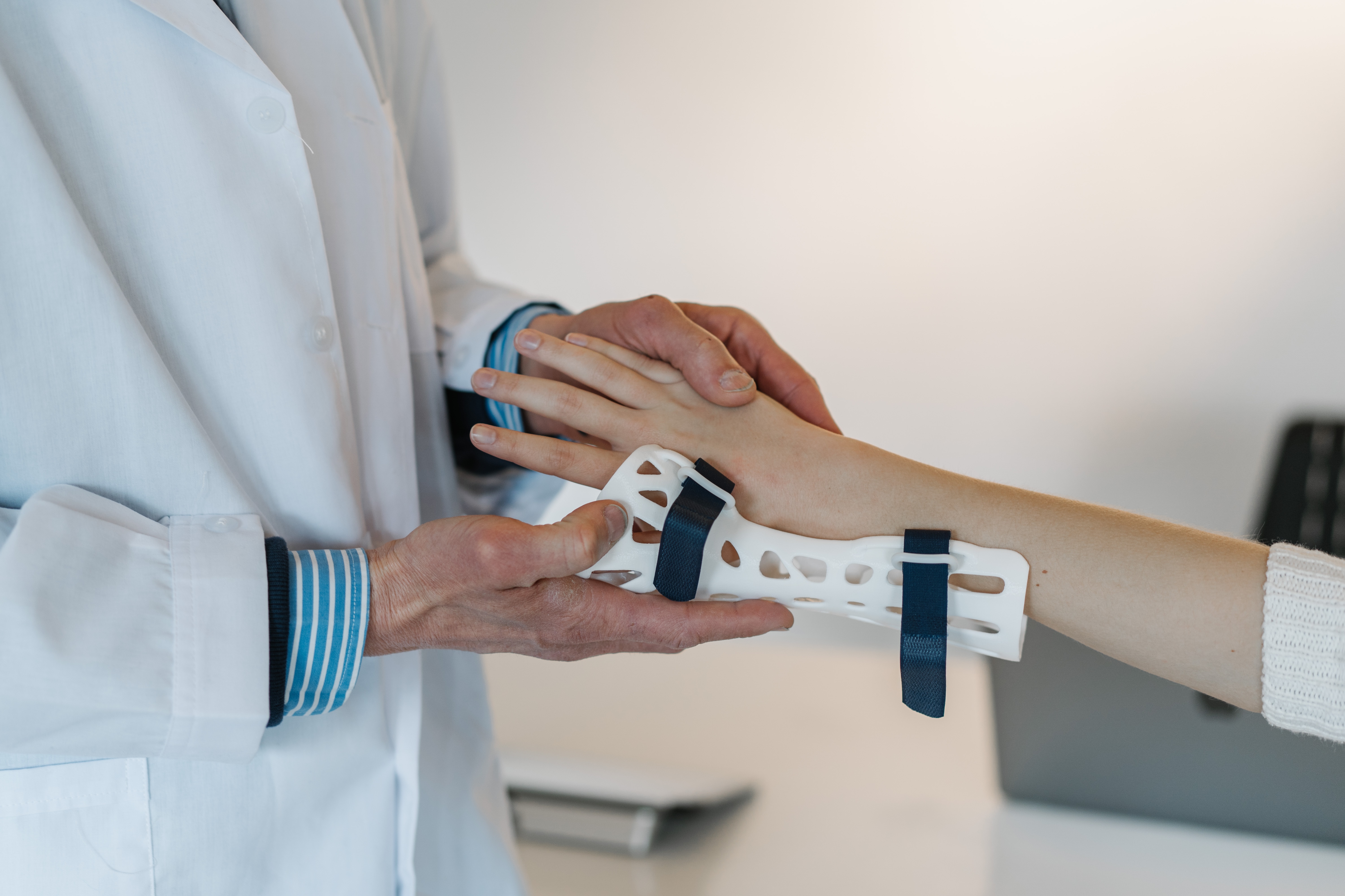 Doctor helping a patient with a broken wrist due to a falling injury.