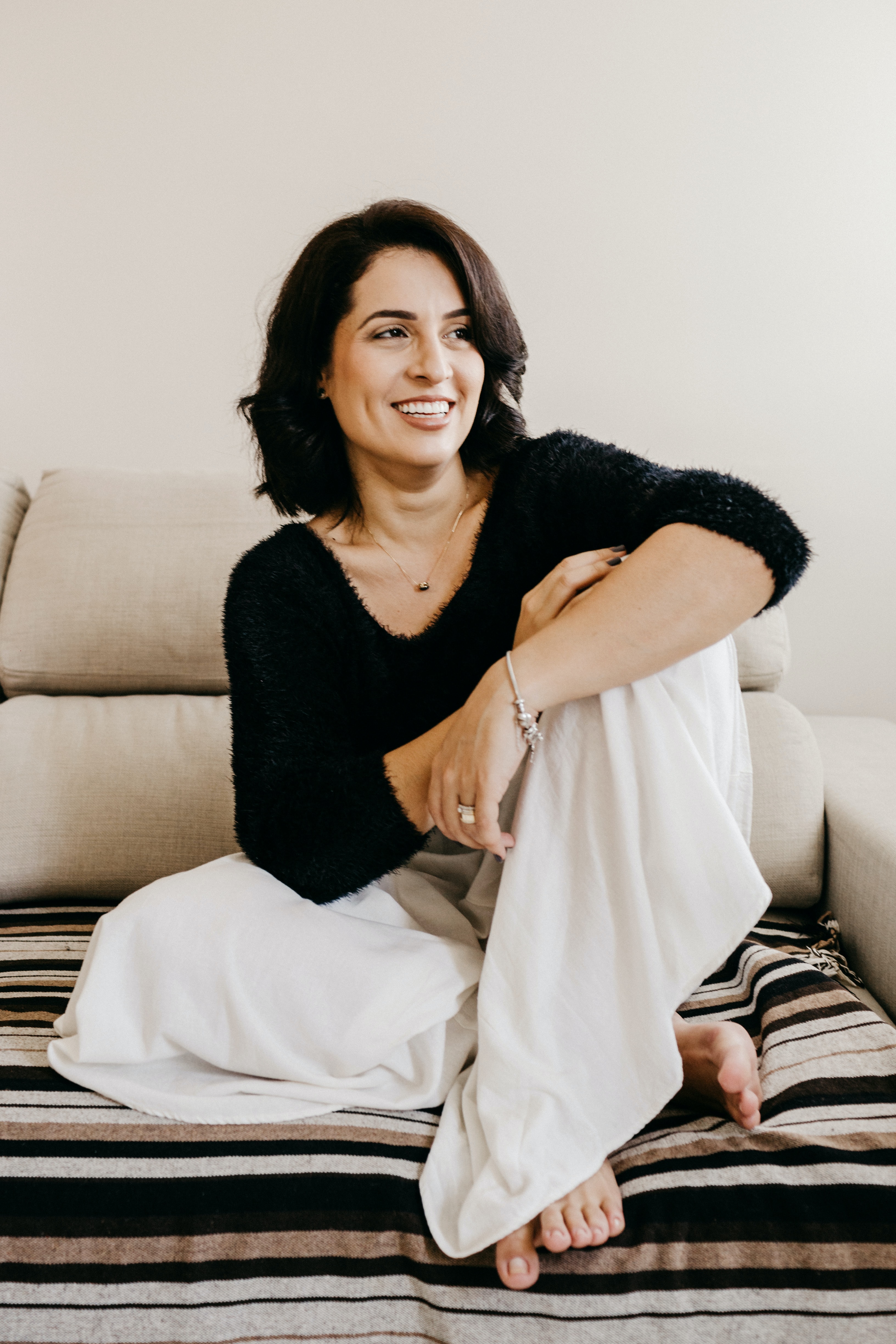 Gen X woman sitting on a couch.