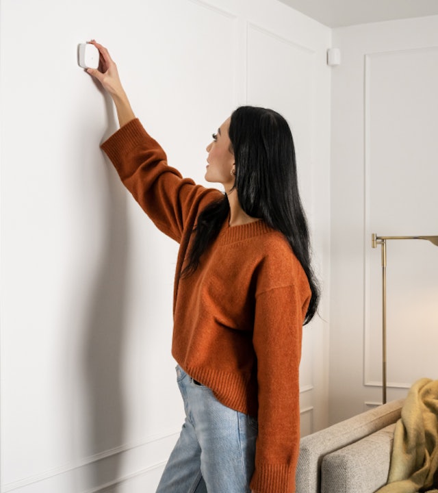 A person peel-and-sticking a Cove sensor with no tools required