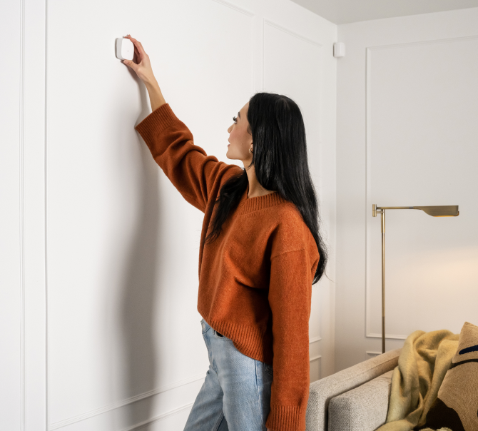 Woman installing glass break detector