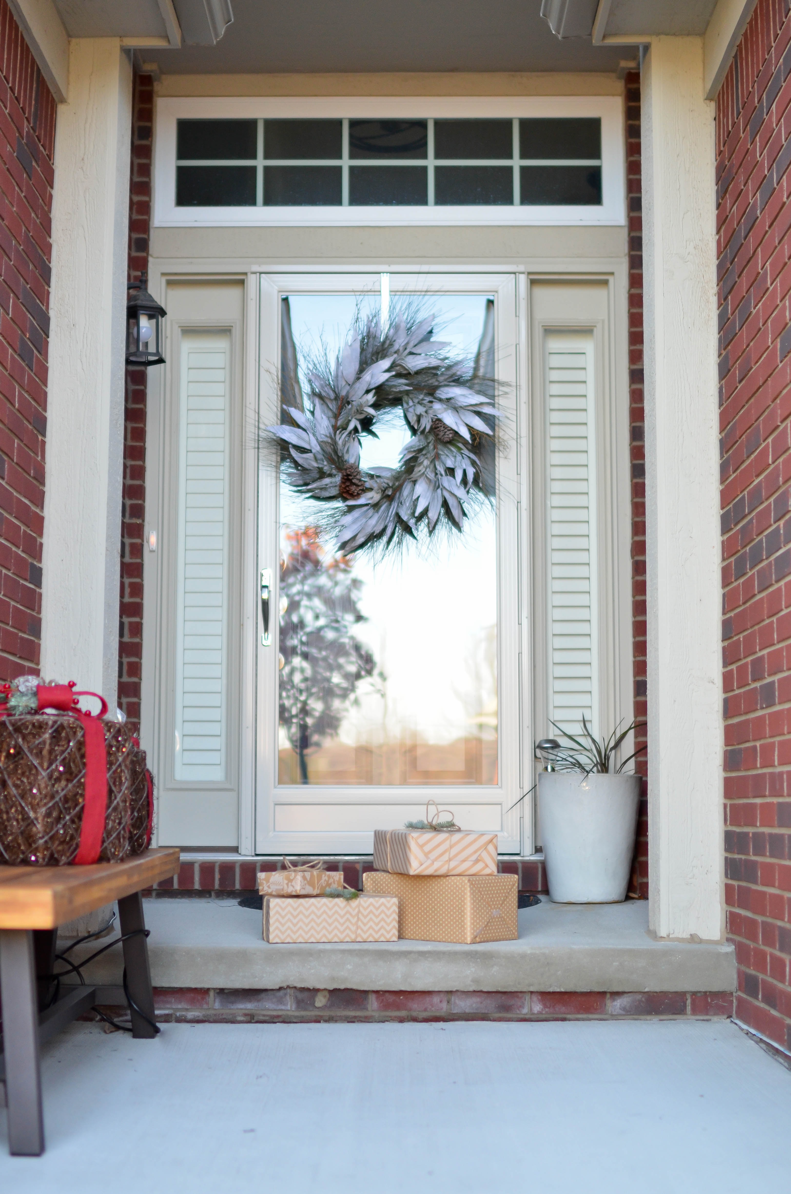 Front porch of a home with packages and a holiday wreath.