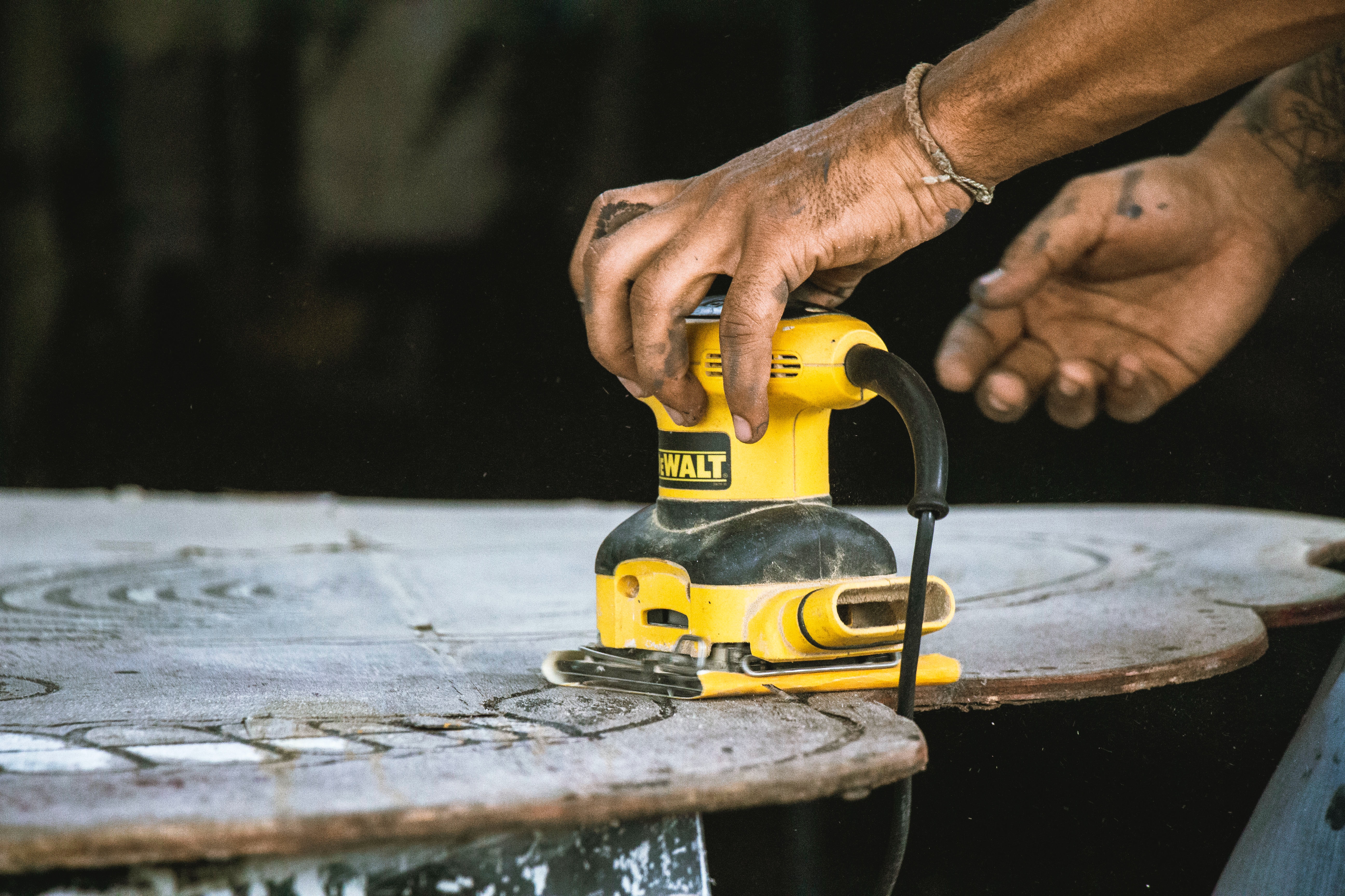 DIYer sanding a piece of wood.