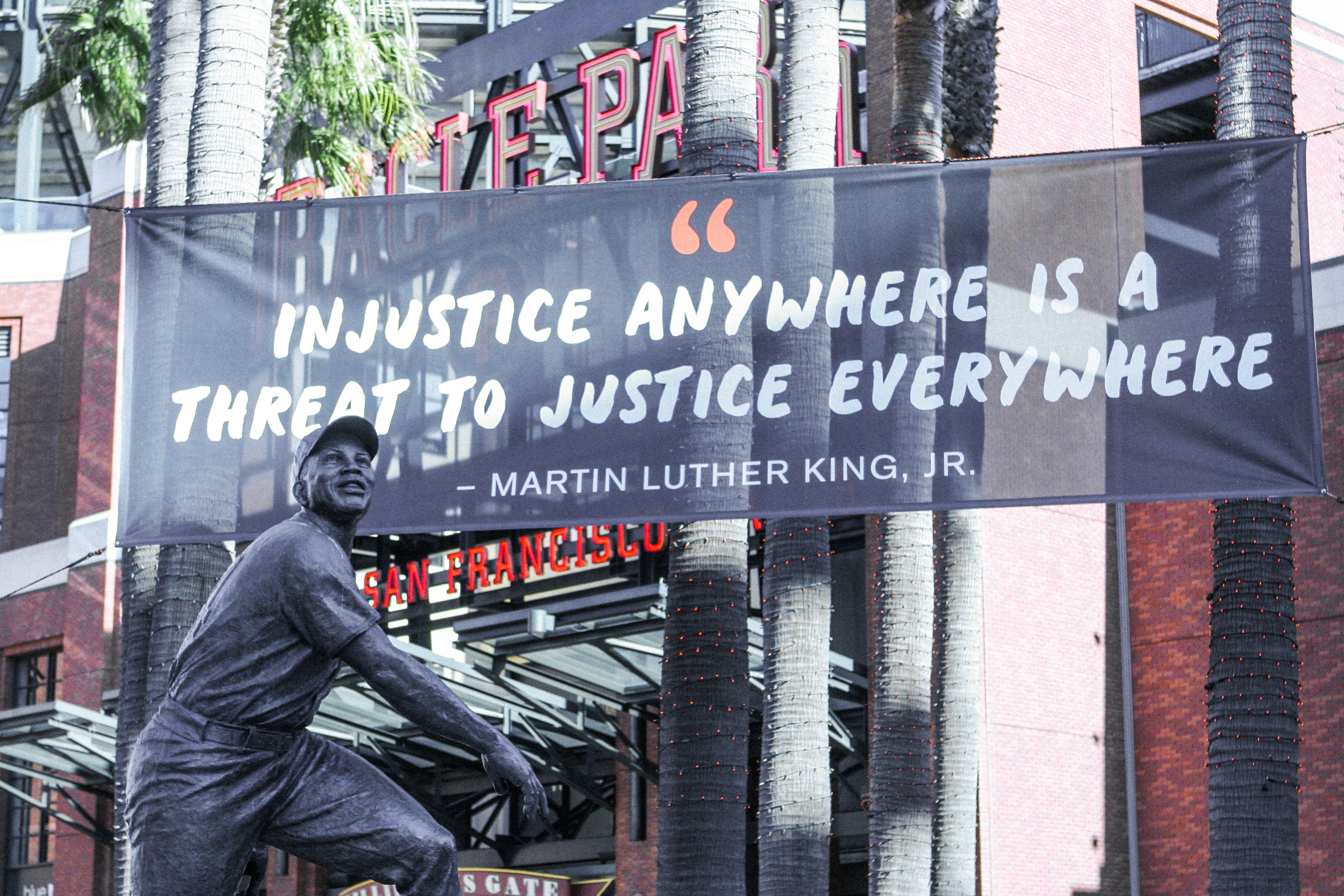 Injustice anywhere is a threat to justice everywhere quote by MLK on a banner