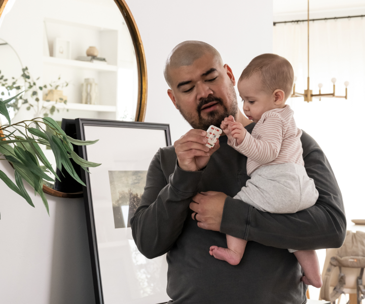 Father installing security system with infant child