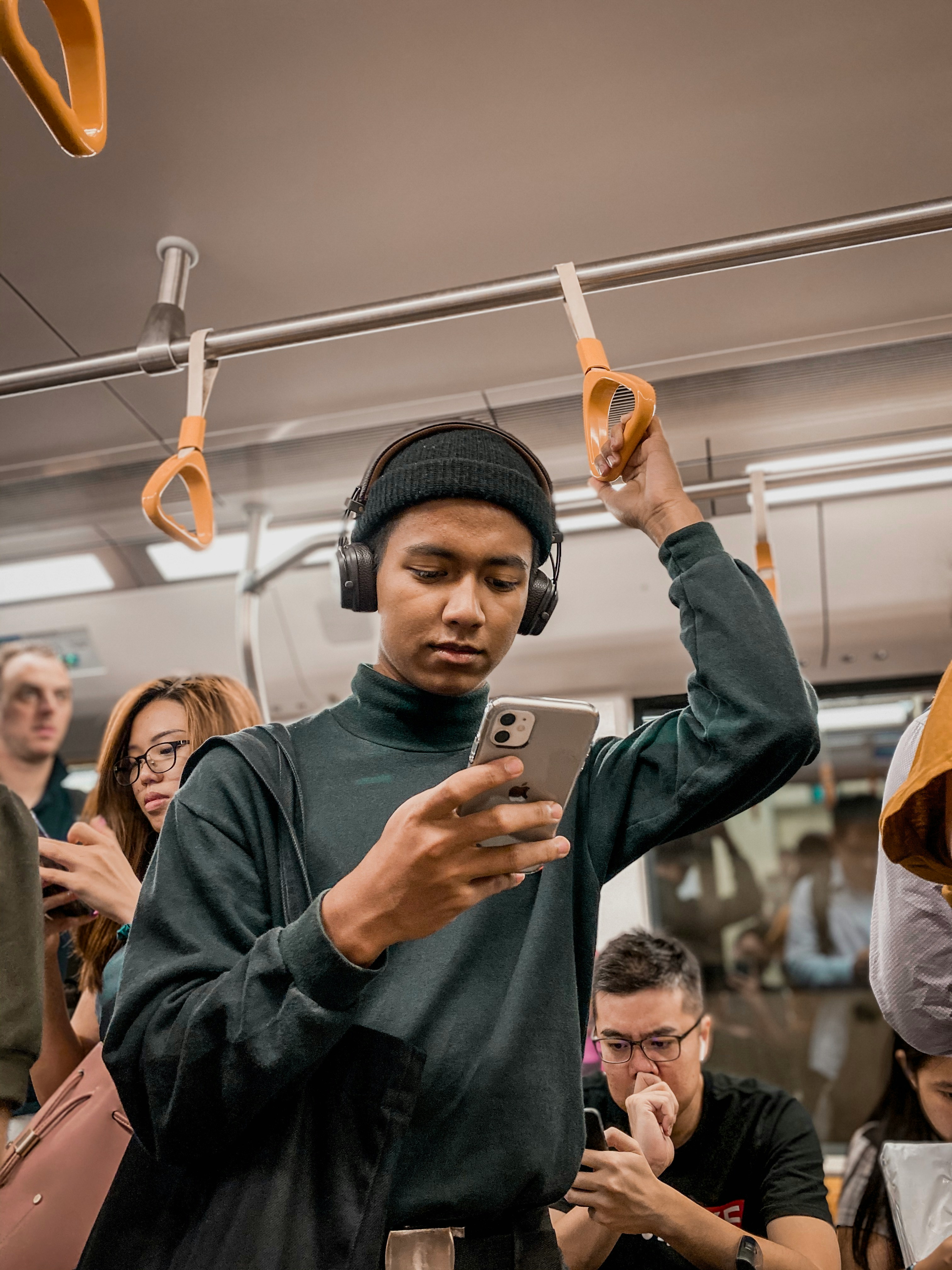 Young man on the subway looking at his phone.
