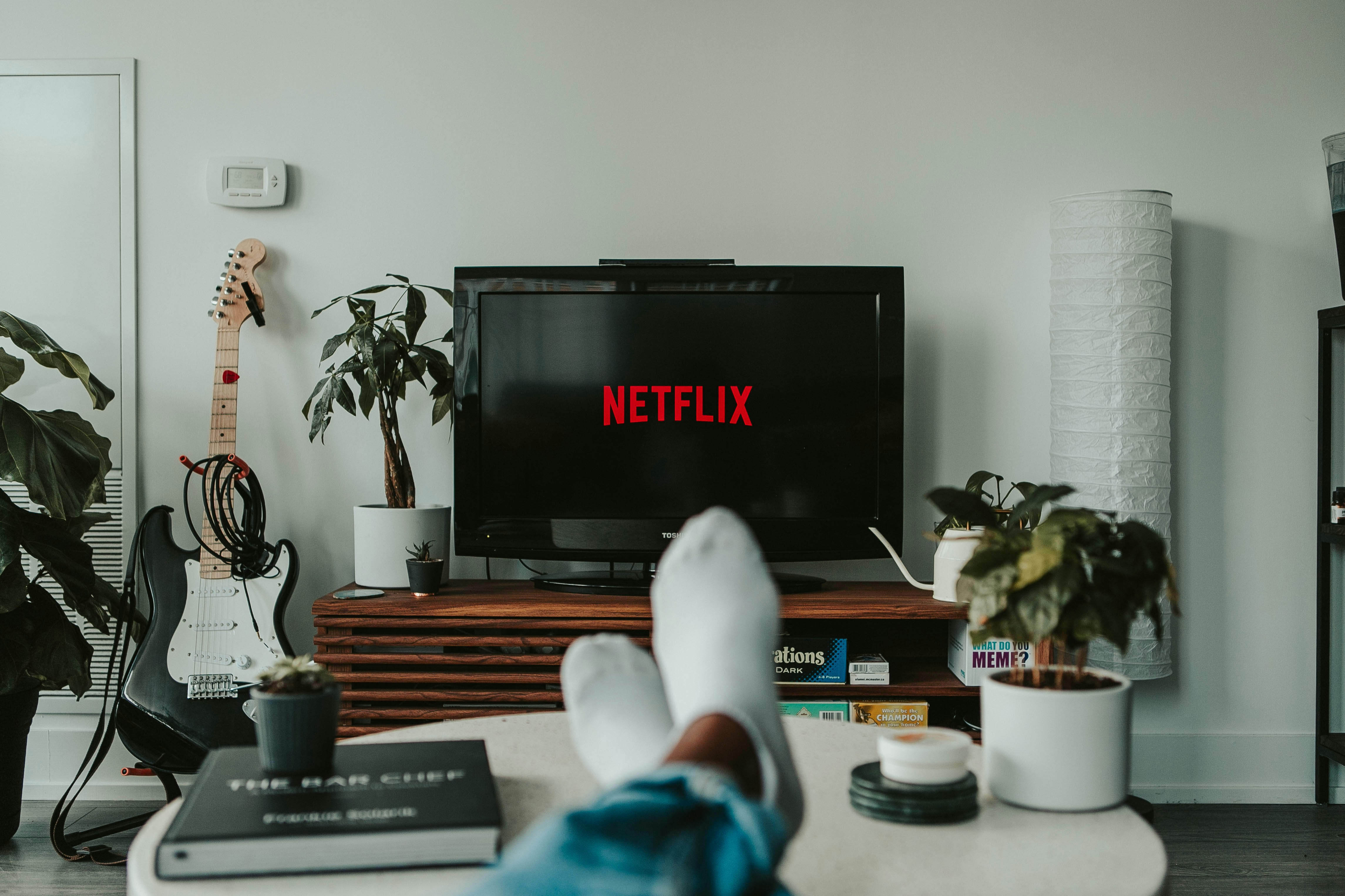 Man sitting on the couch watching Netflix on his tv in the living room.