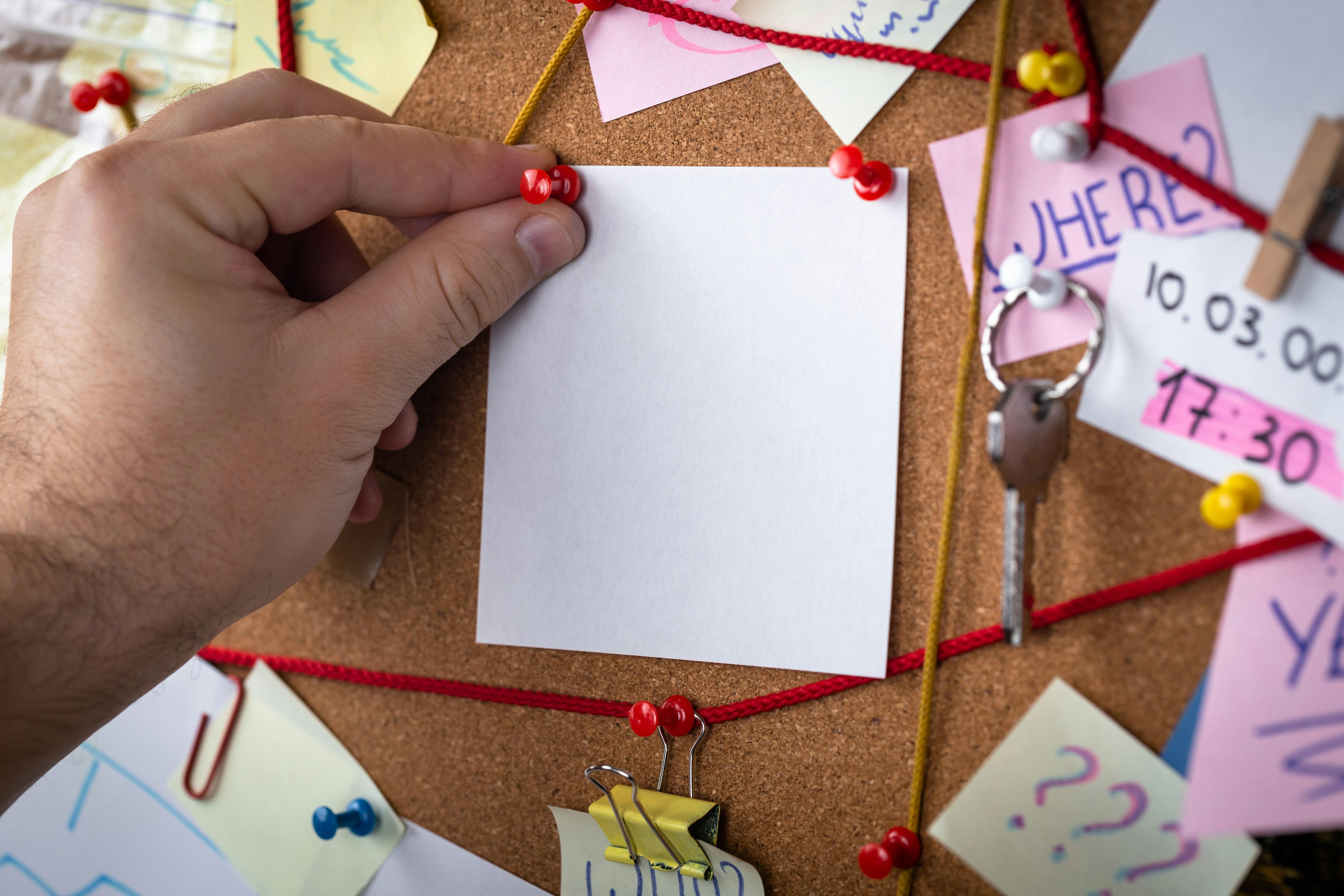 Detective using a corkboard to figure out a crime.