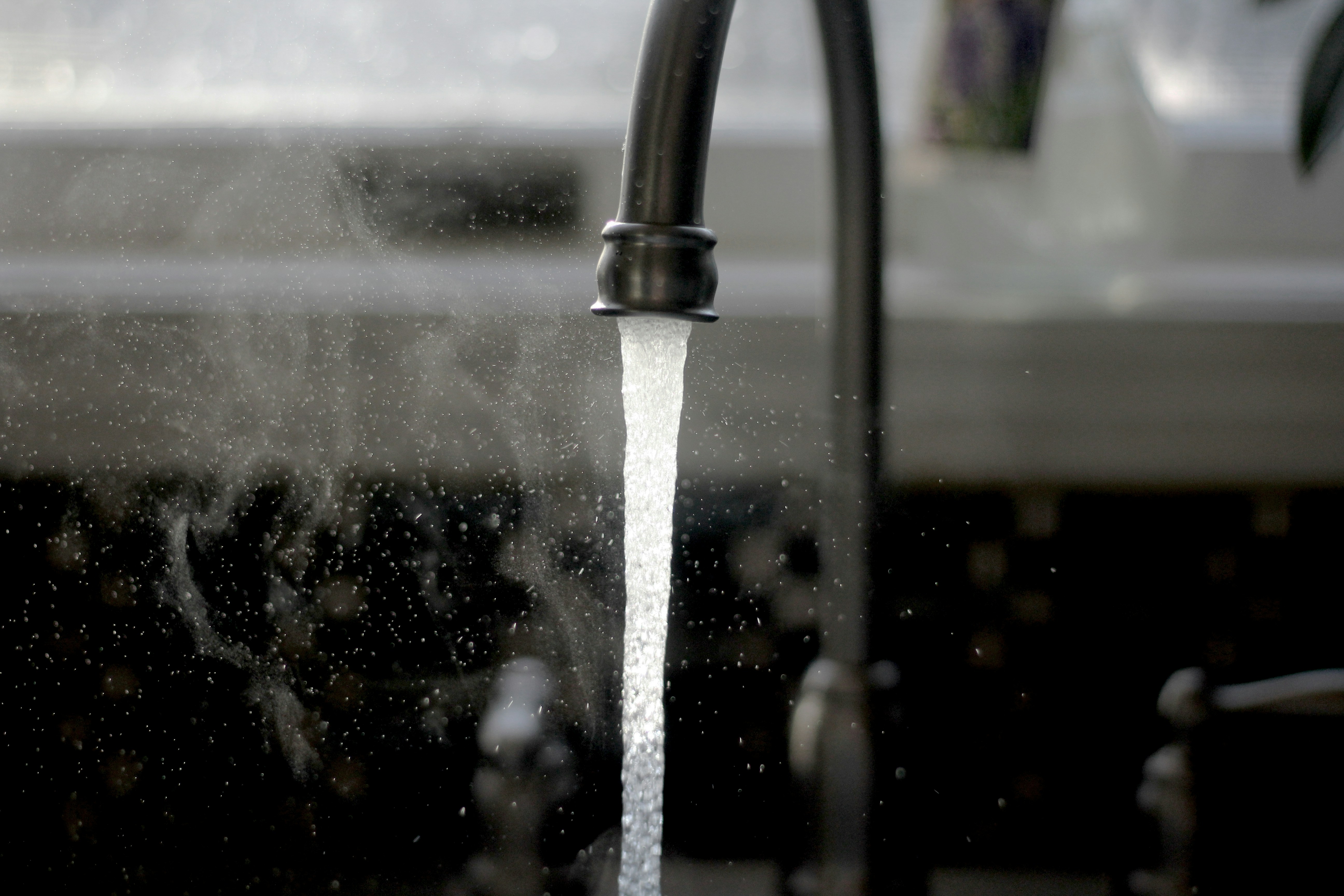 Water running out of a tap into a sink.