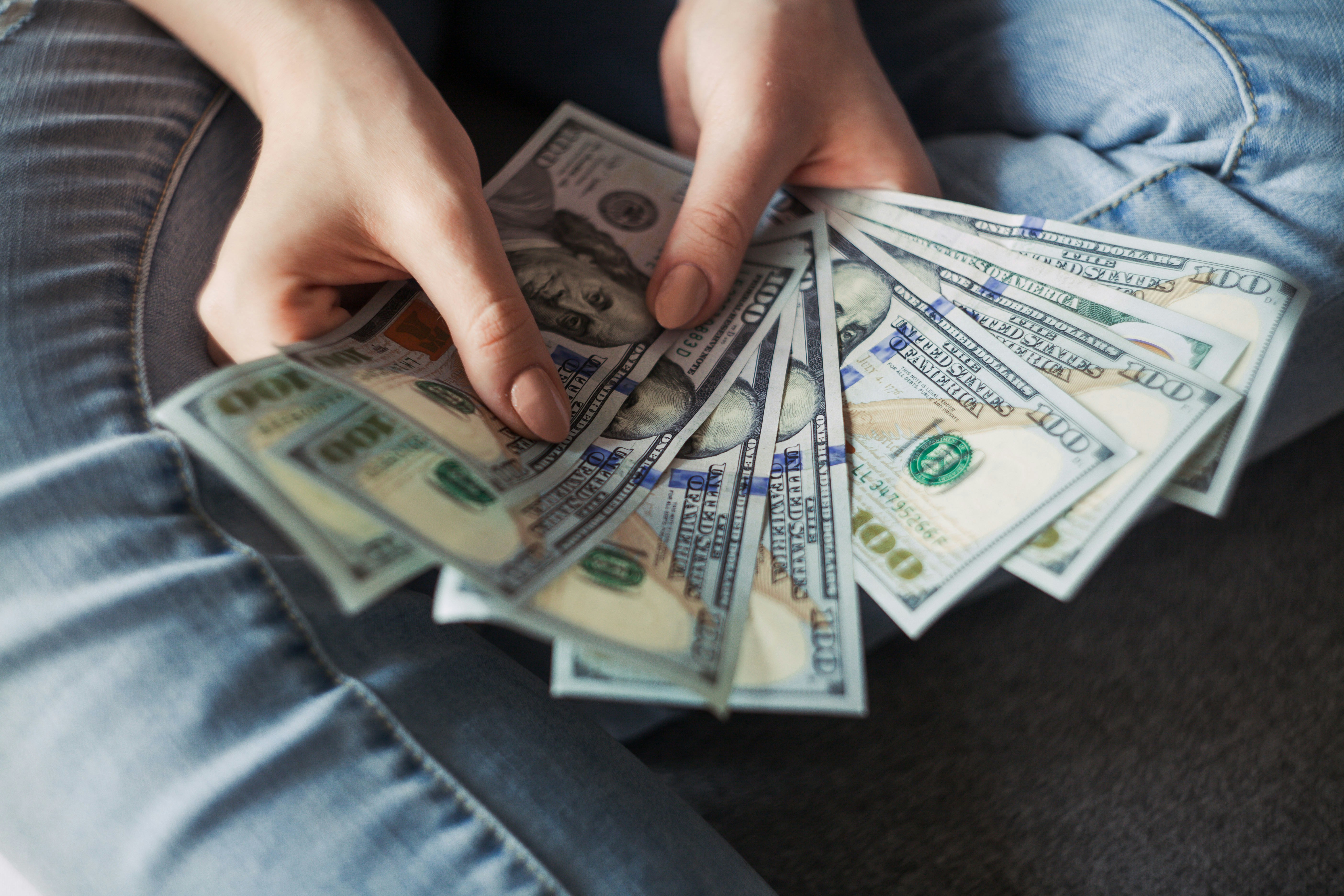 Person holding money they are hiding in their home.