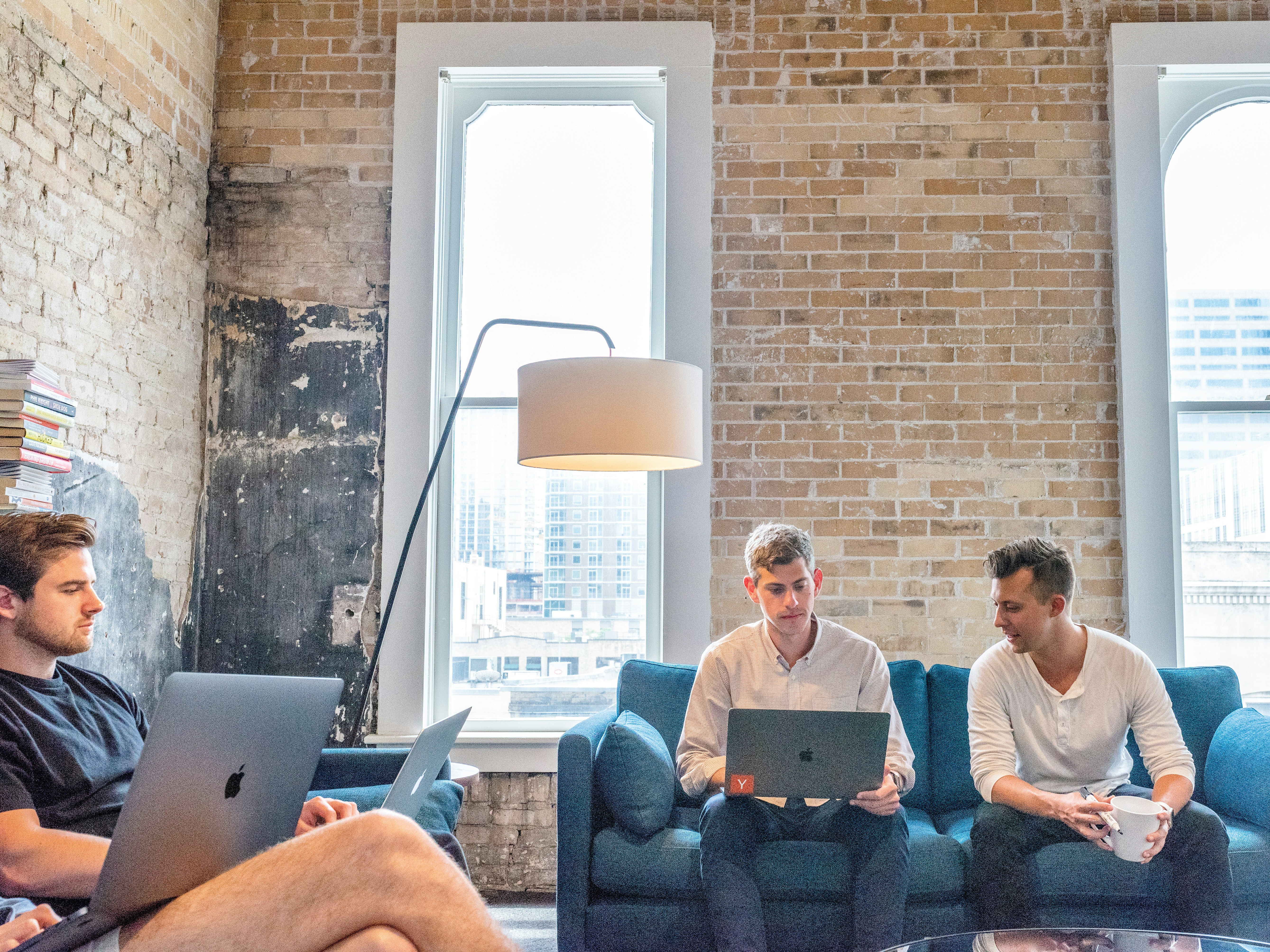 Three men sitting in their living room they share as roommates.