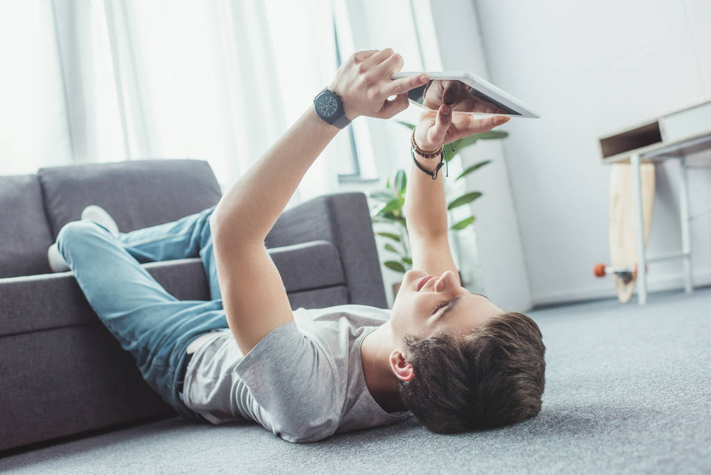 Teen boy playing a game on a device.