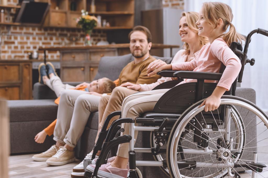 Girl in a wheelchair with her family at home.