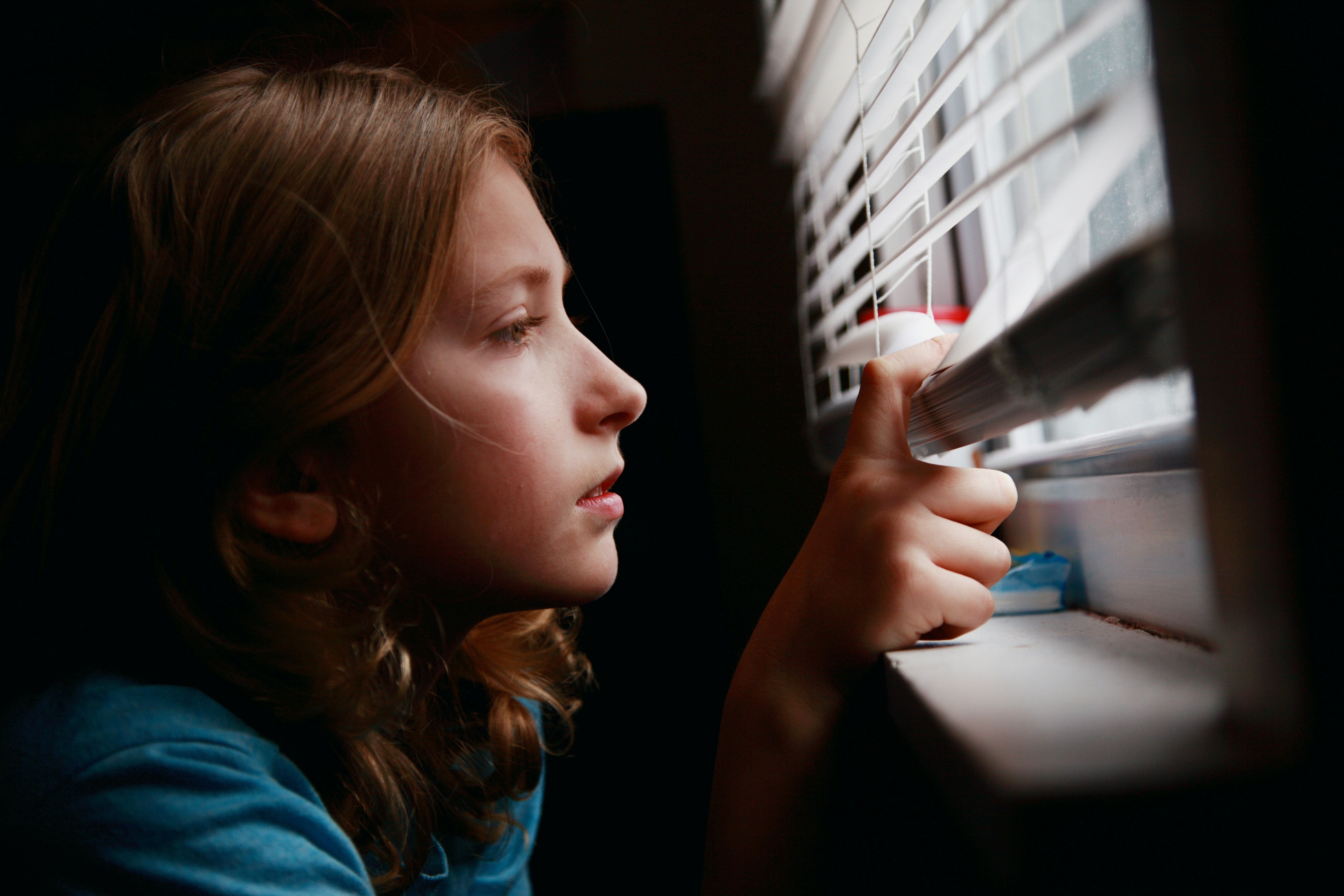 Girl looking through her bedroom window.