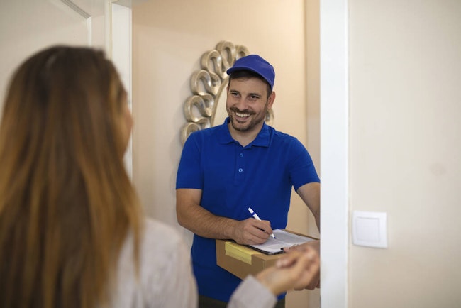 Delivery man with a box at a woman's front door.