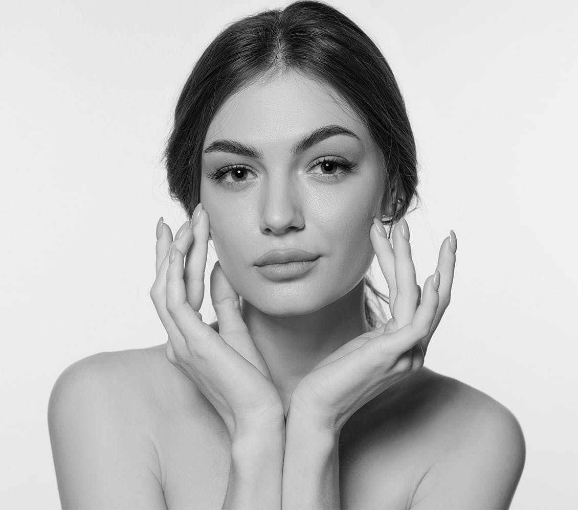 black and white image of a woman cupping her face