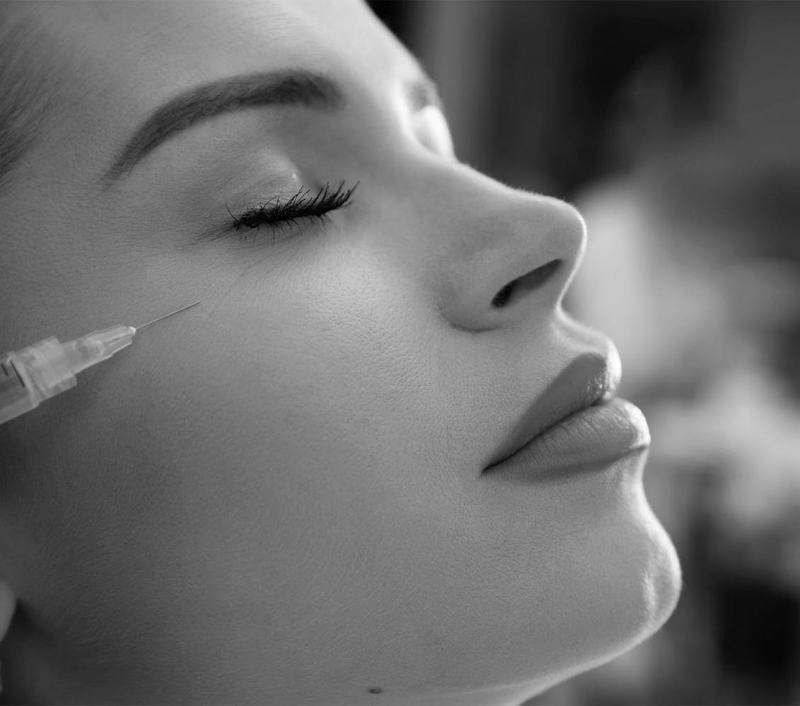 black and white photo of a woman getting an injection