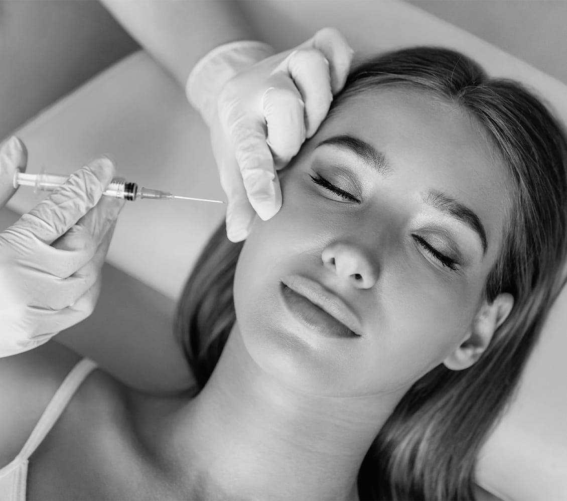 black and white photo of a woman getting a face injection