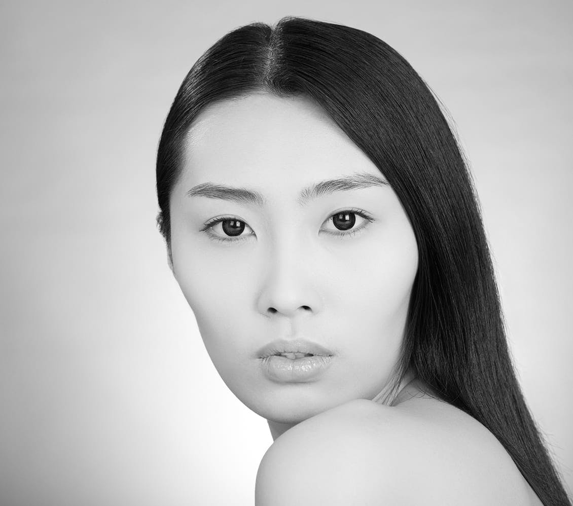 black and white photo of a woman touching her chin