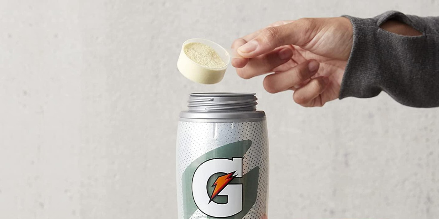 Athlete pouring protein powder into a Gatorade Bottle