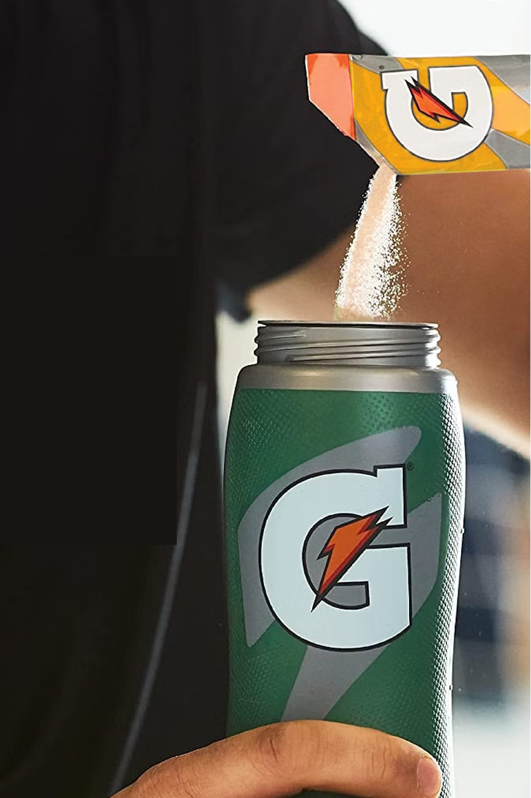 Gatorade thirst quencher single serve powder orange being poured into Gx bottle