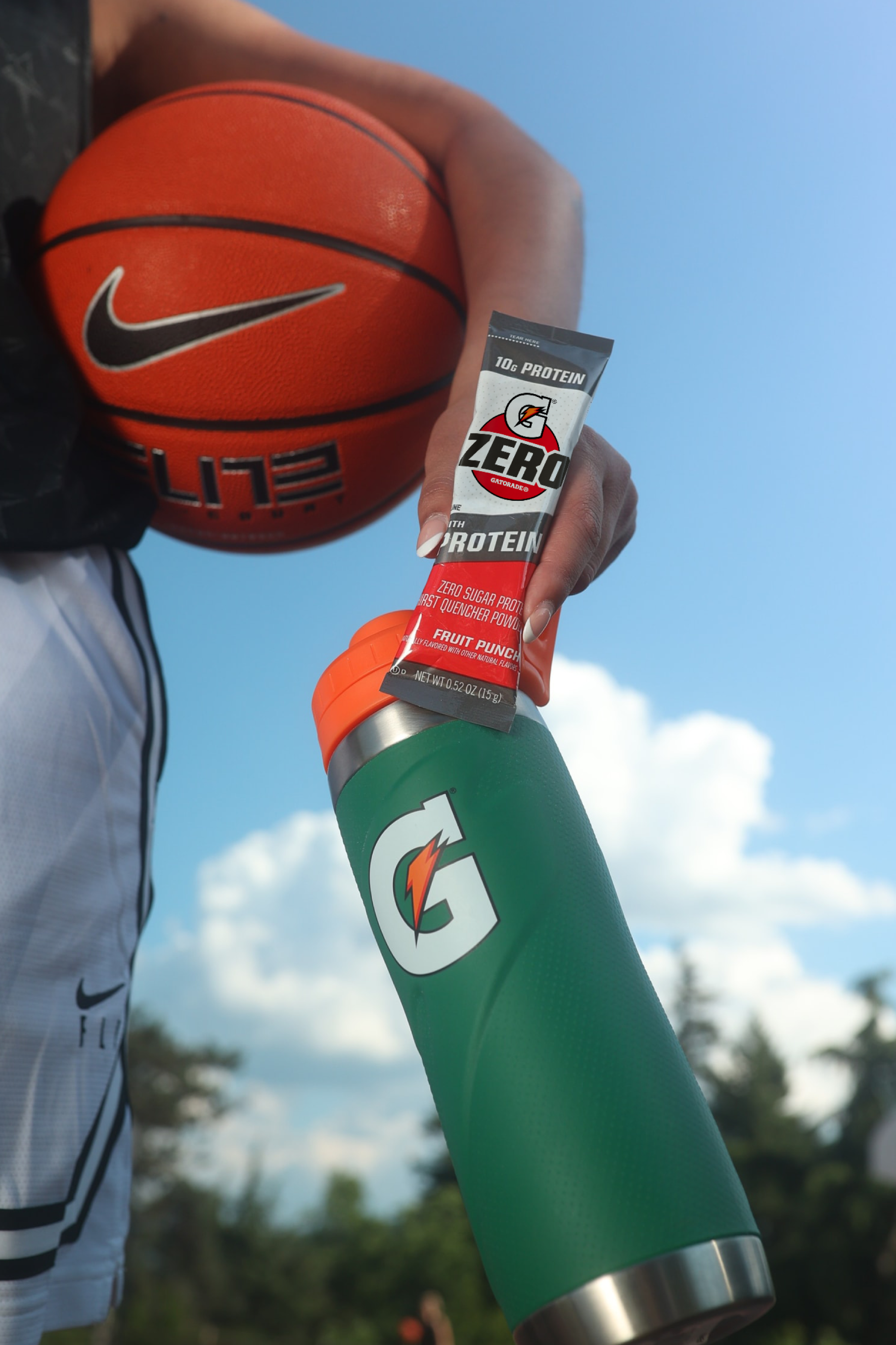G Zero with Protein held next to a basketball and Gx Stainless Steel bottle
