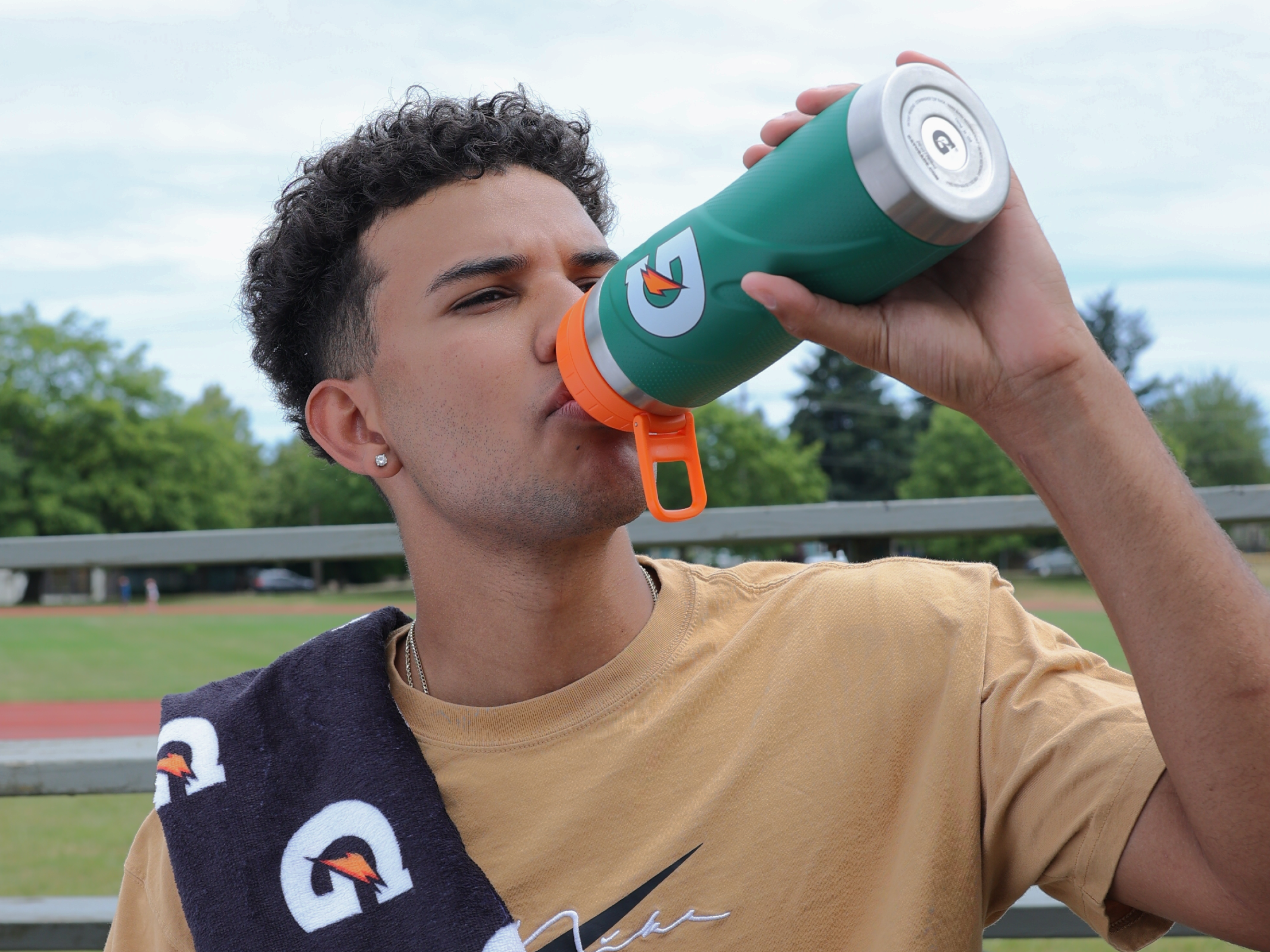 Athlete drinking out of Gx stainless steel bottle