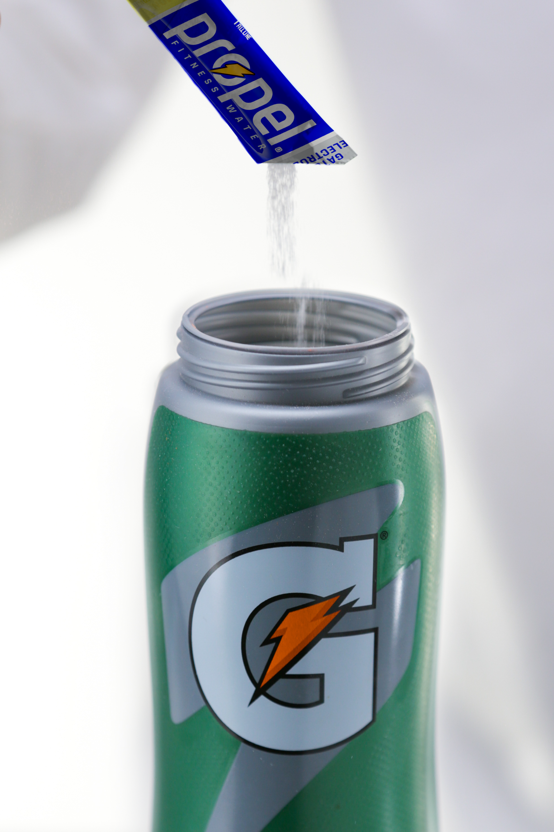 Propel single serve lemon powder being poured into Gx bottle