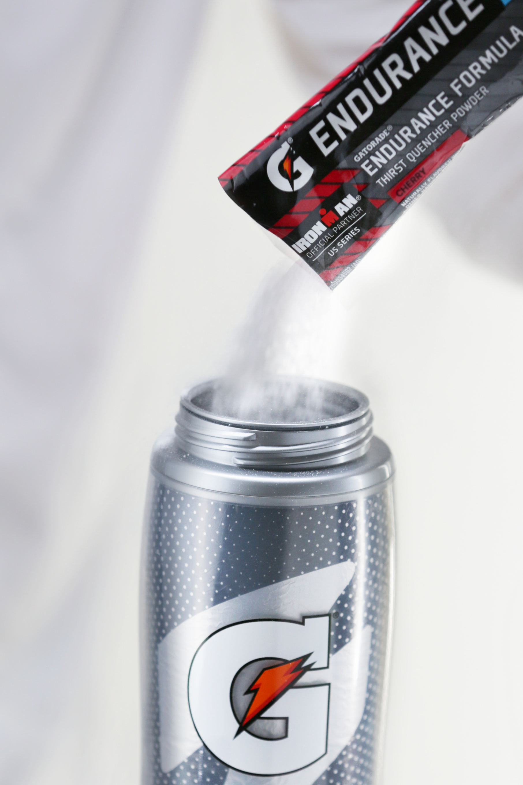 Cherry endurance single serve powder being poured into Gx bottle