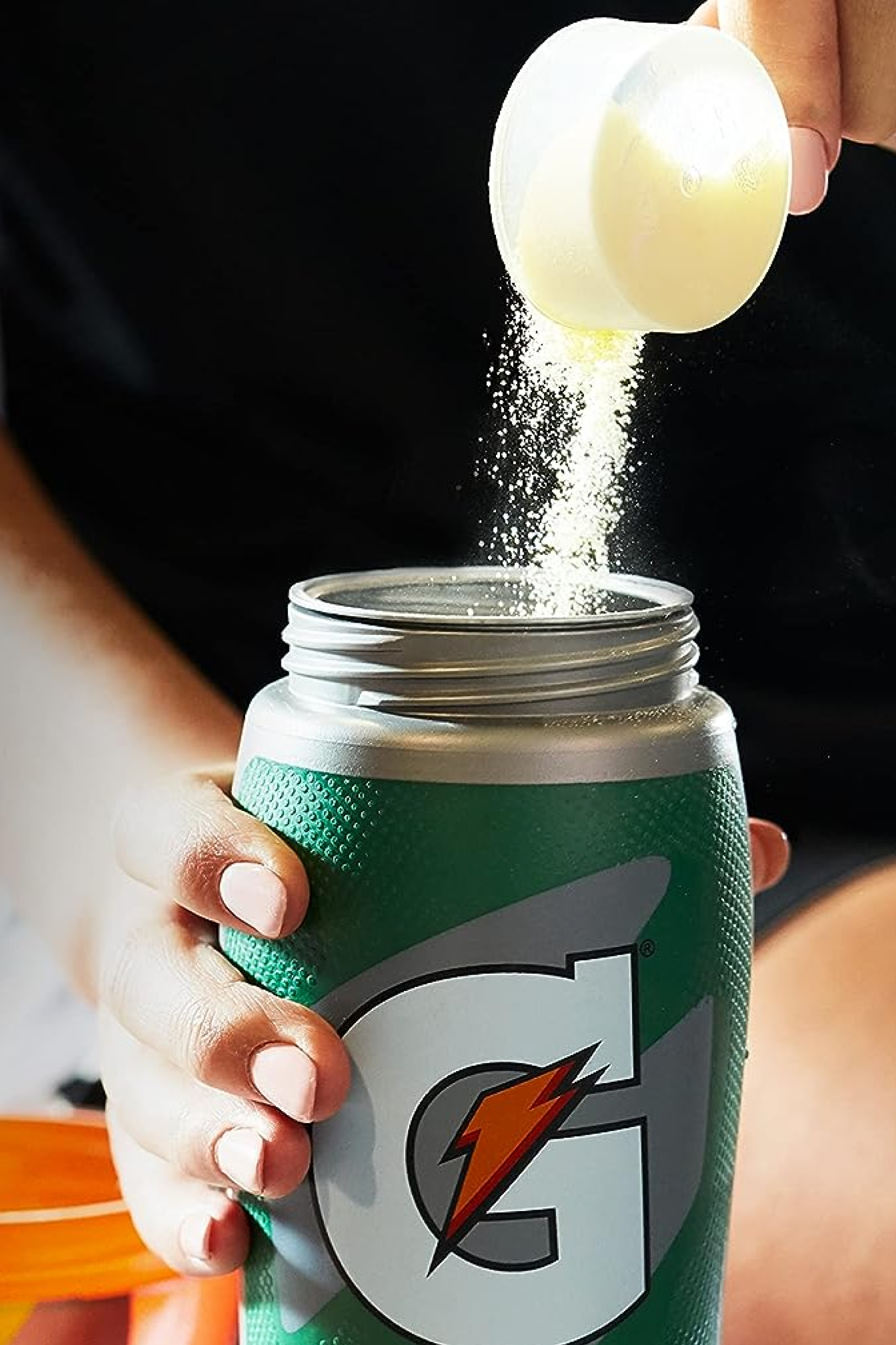 Gatorade thirst quencher powder being poured into Gx bottle