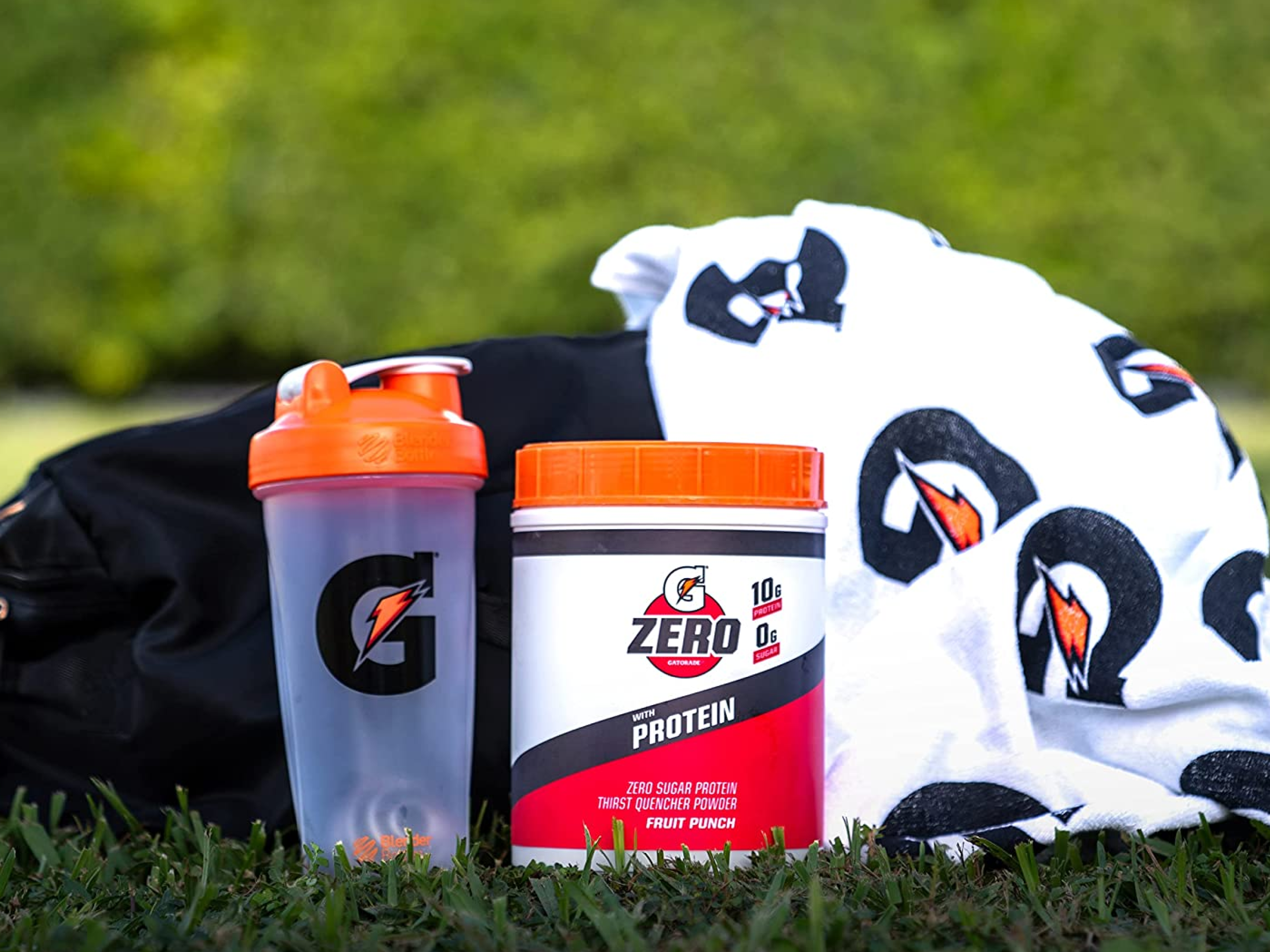 G Zero with Protein canister on a field with Gatorade products