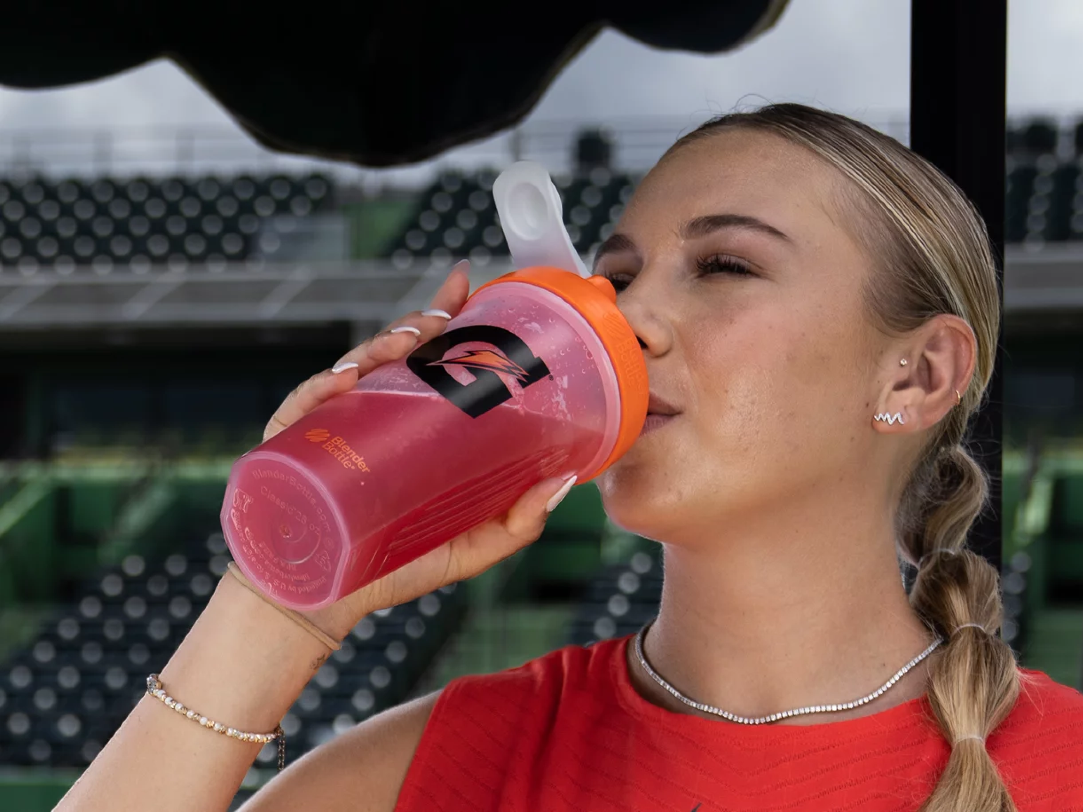 Athlete drinking out of transparent shaker bottle