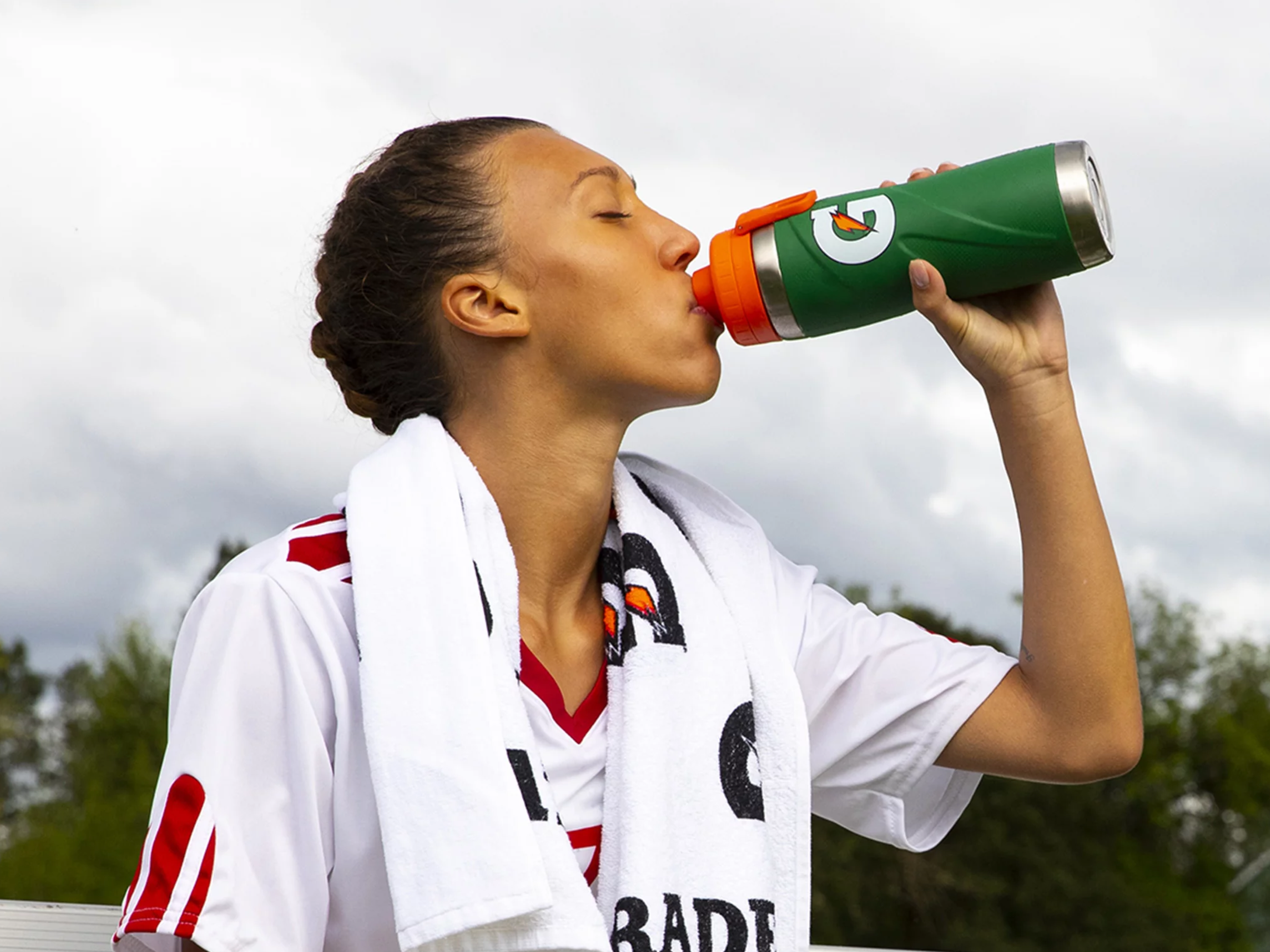 Athlete drinking out of green stainless steel bottle