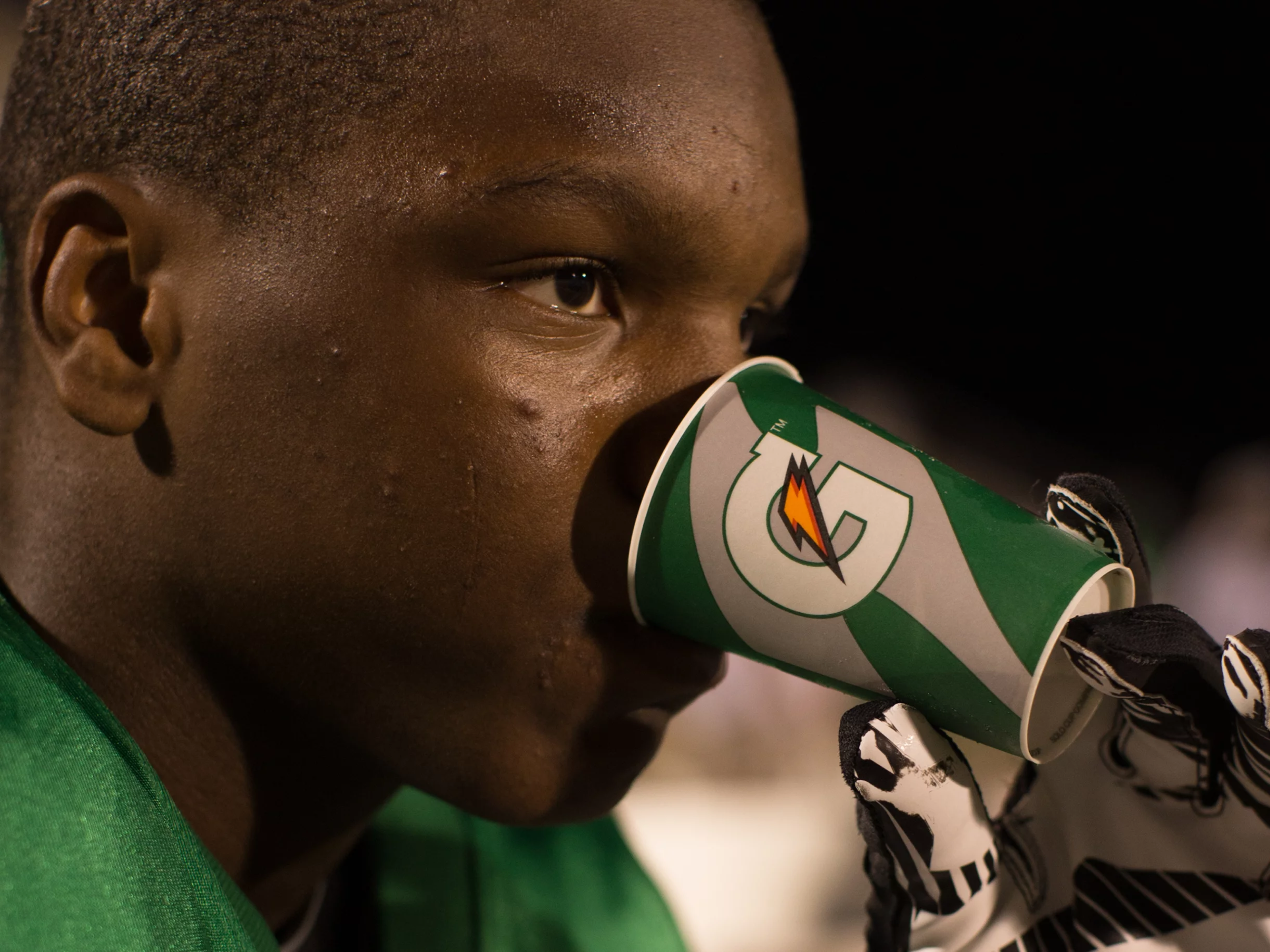 Athlete drinking from a green Gatorade cup