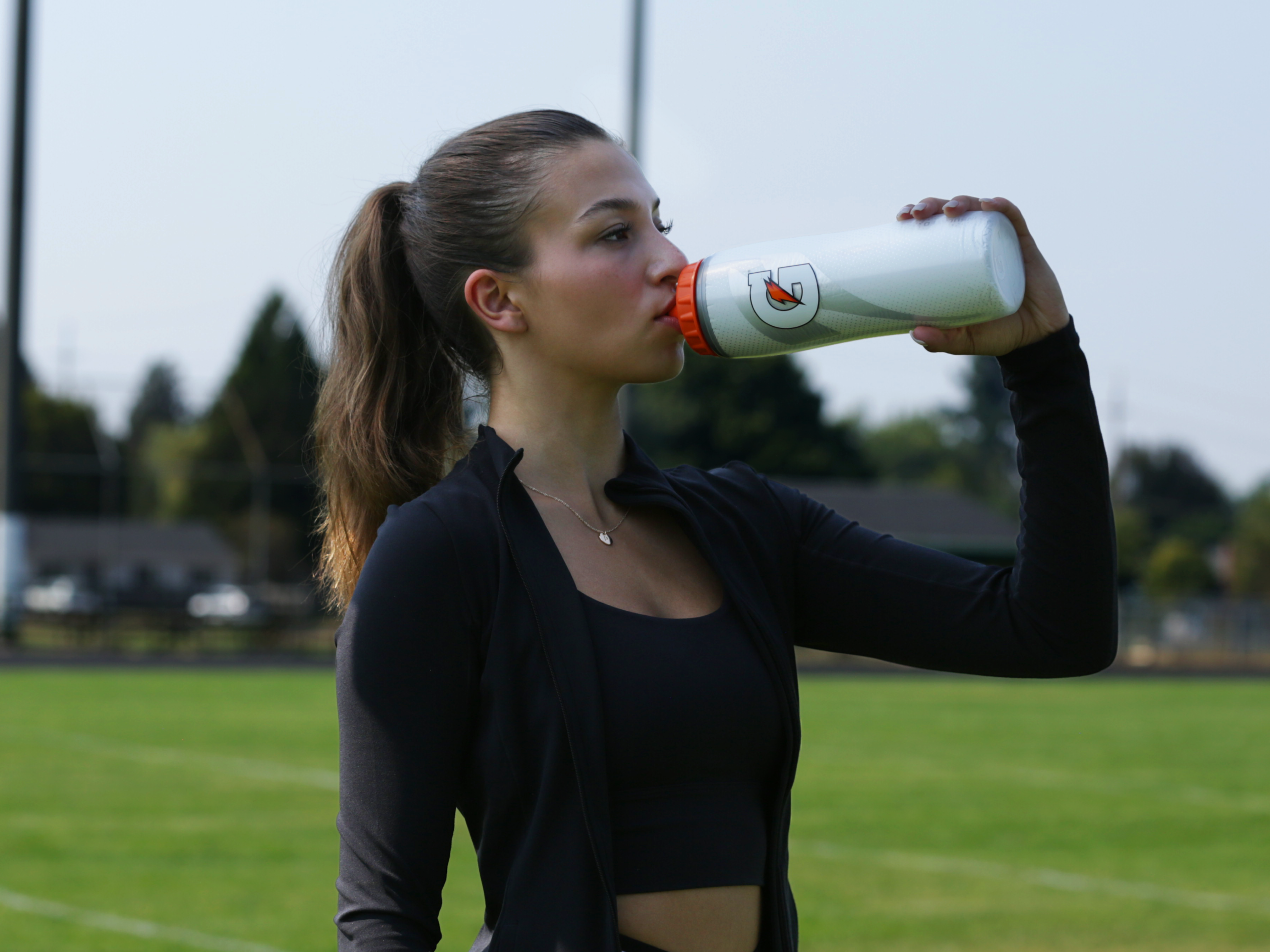Athlete drinking out of white insulated bottle