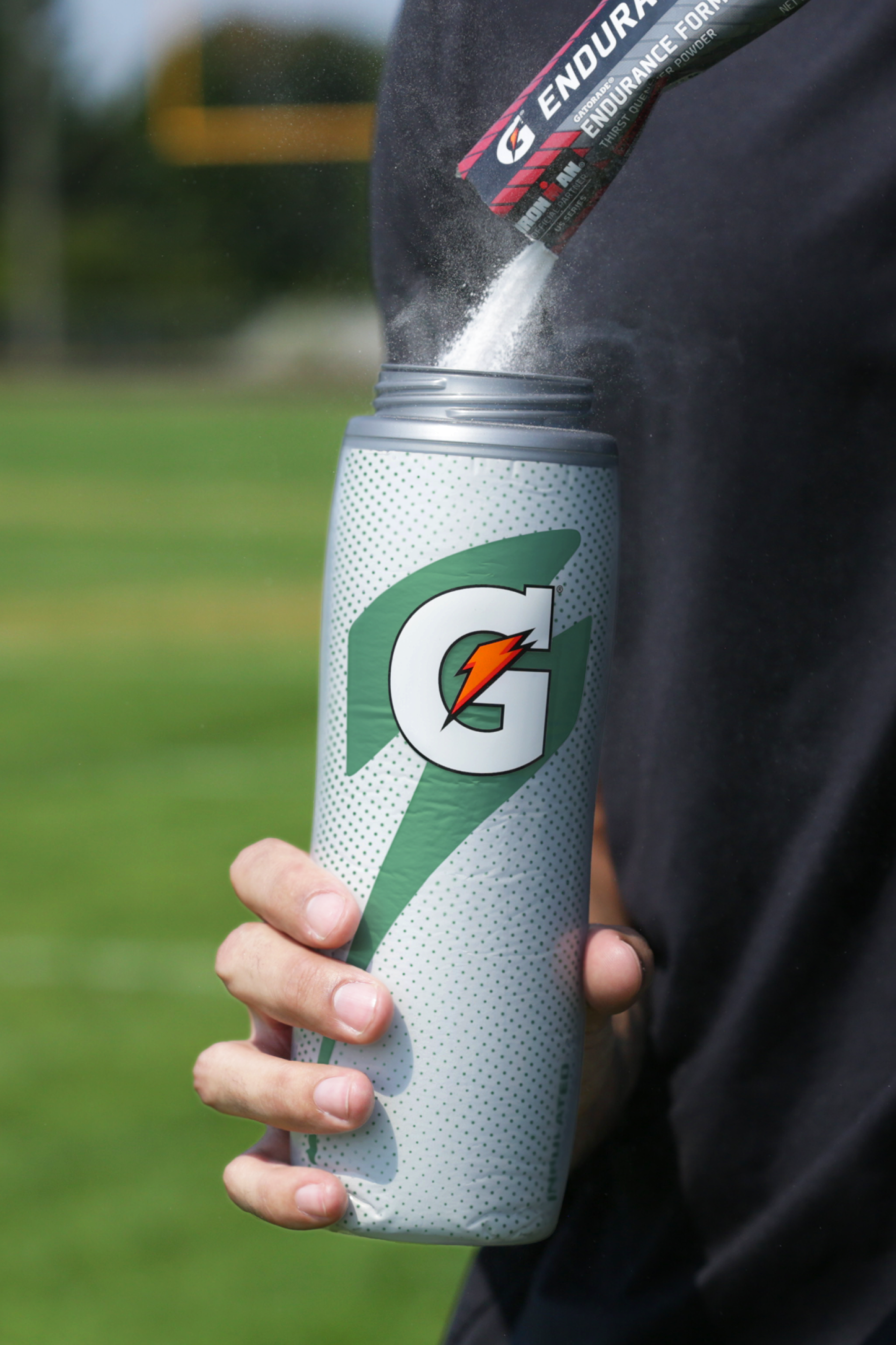Powder being poured into silver insulated squeeze bottle