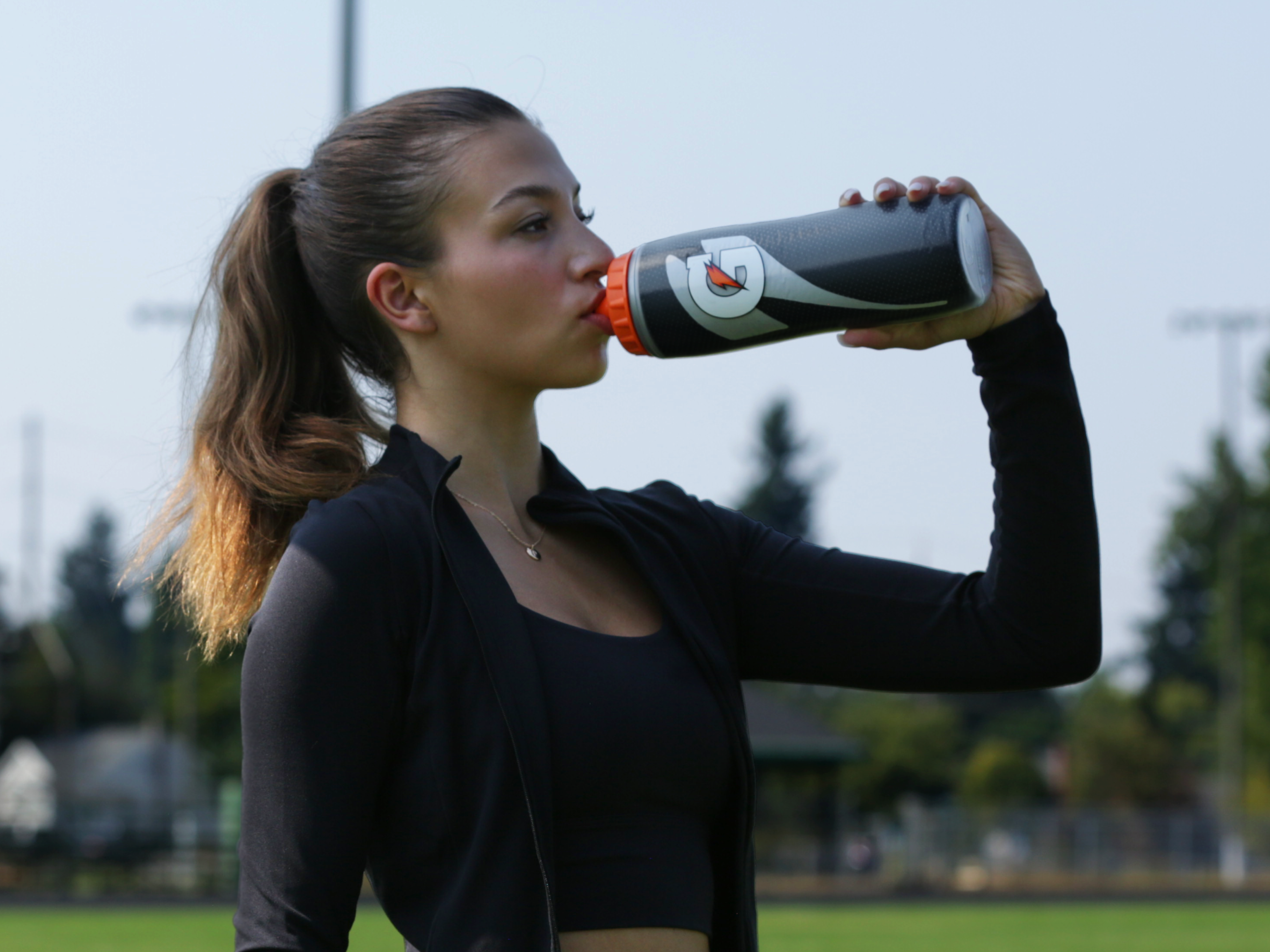 Athlete drinking from black insulated bottle