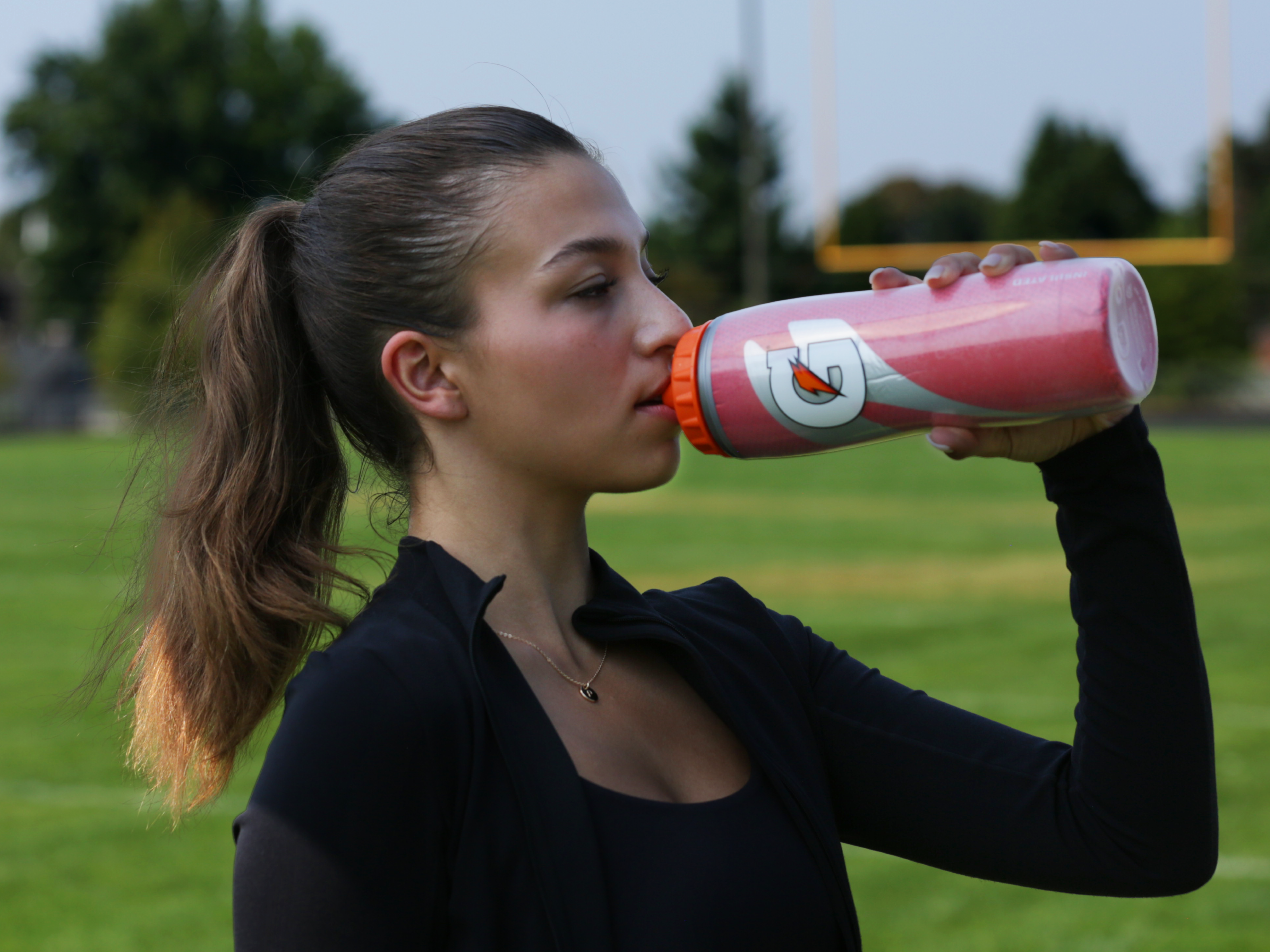 Athlete drinking from red insulated bottle