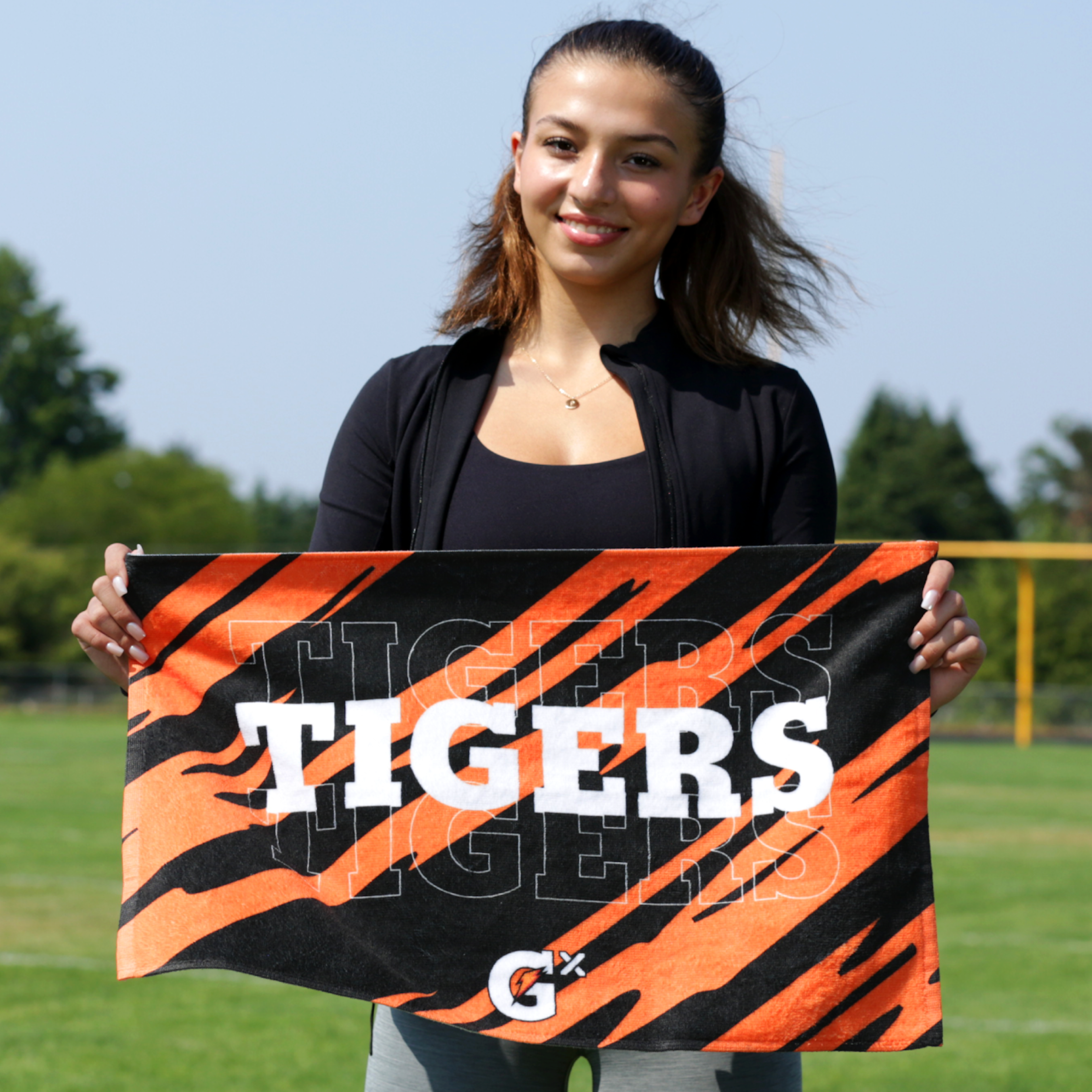 Social share image of athlete holding a custom Gatorade ID Towel on a football field.