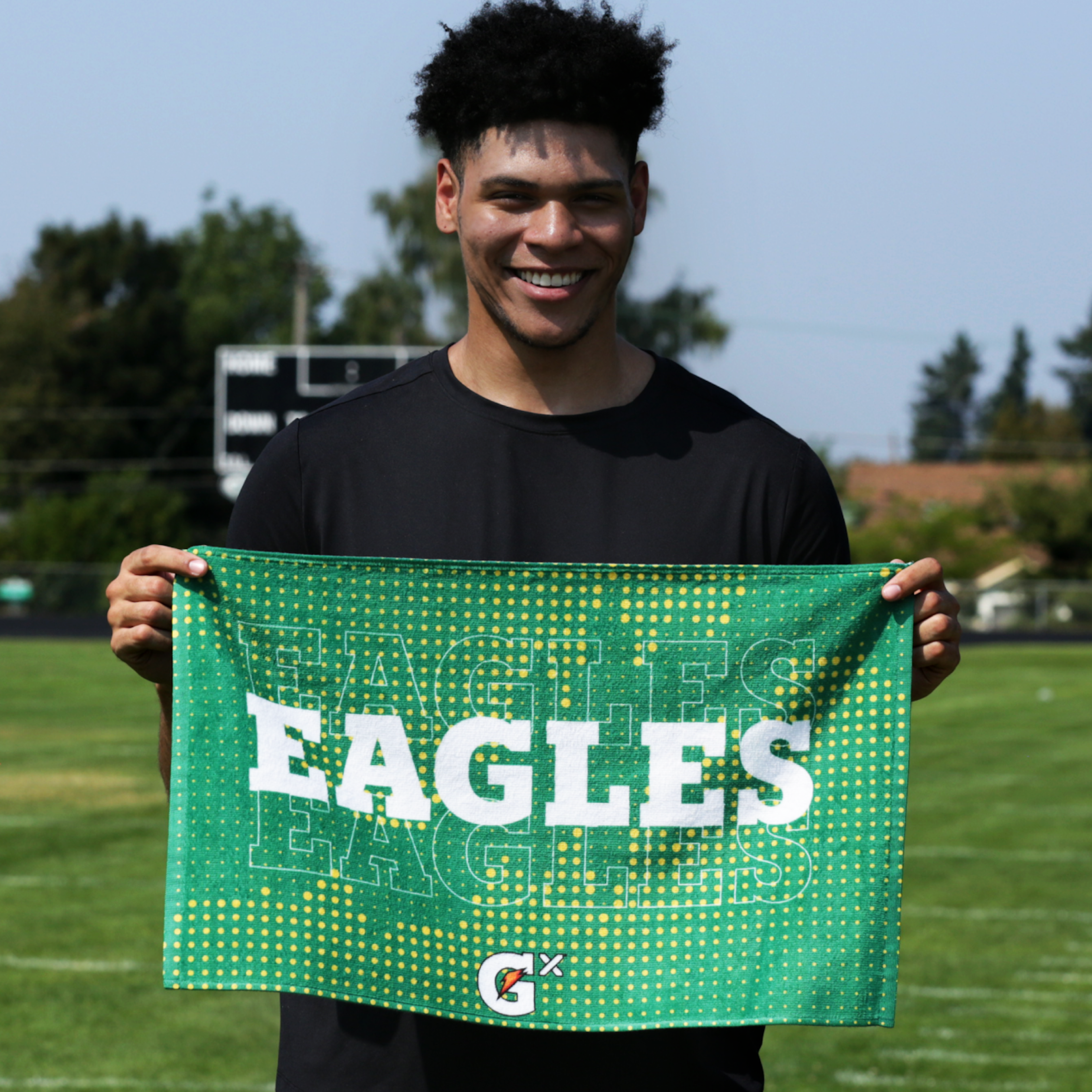 Social share image of athlete holding a custom Gatorade ID Towel on a football field.