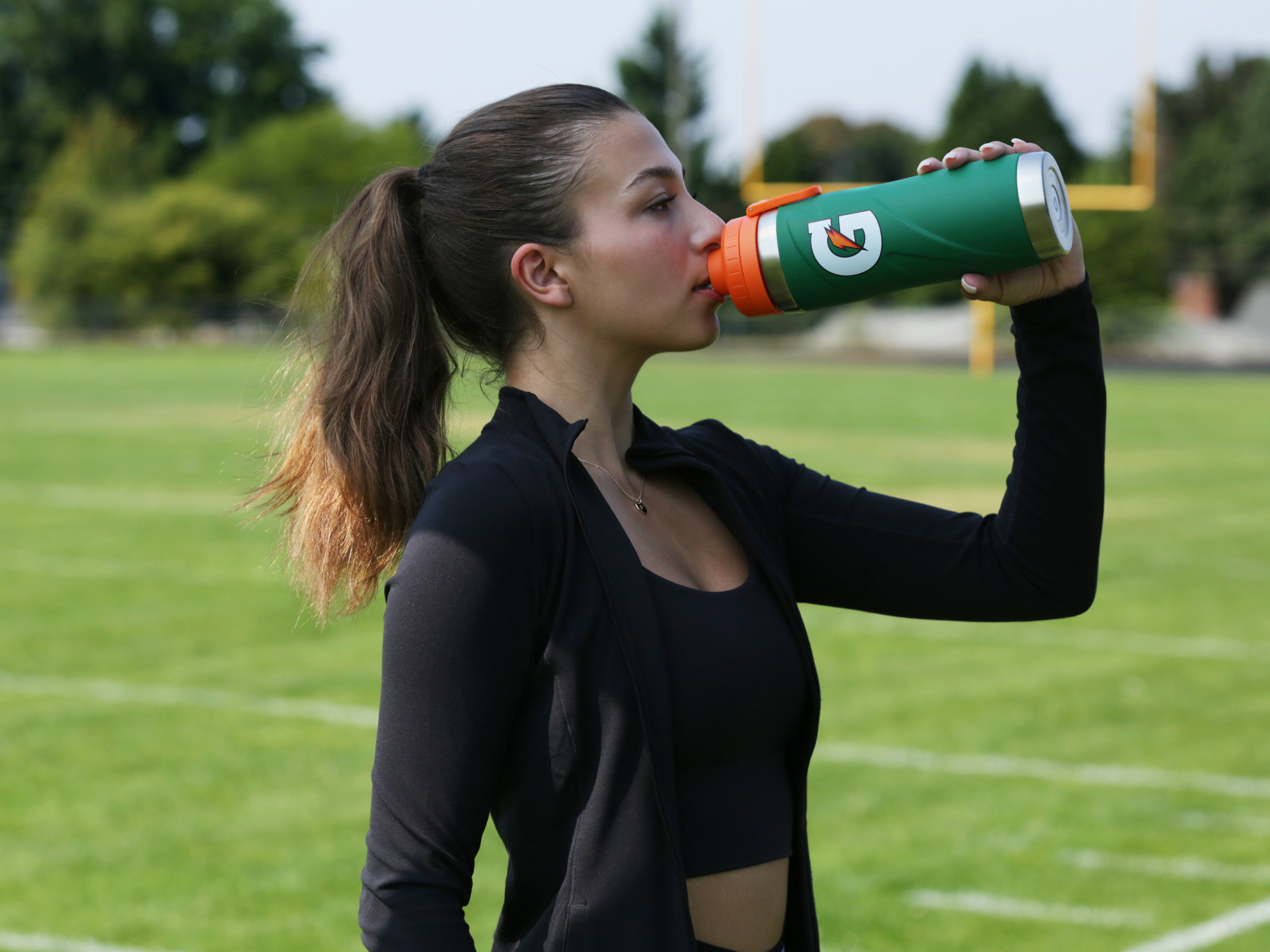 Athlete drinking from a Green Gx Stainless Steel Bottle