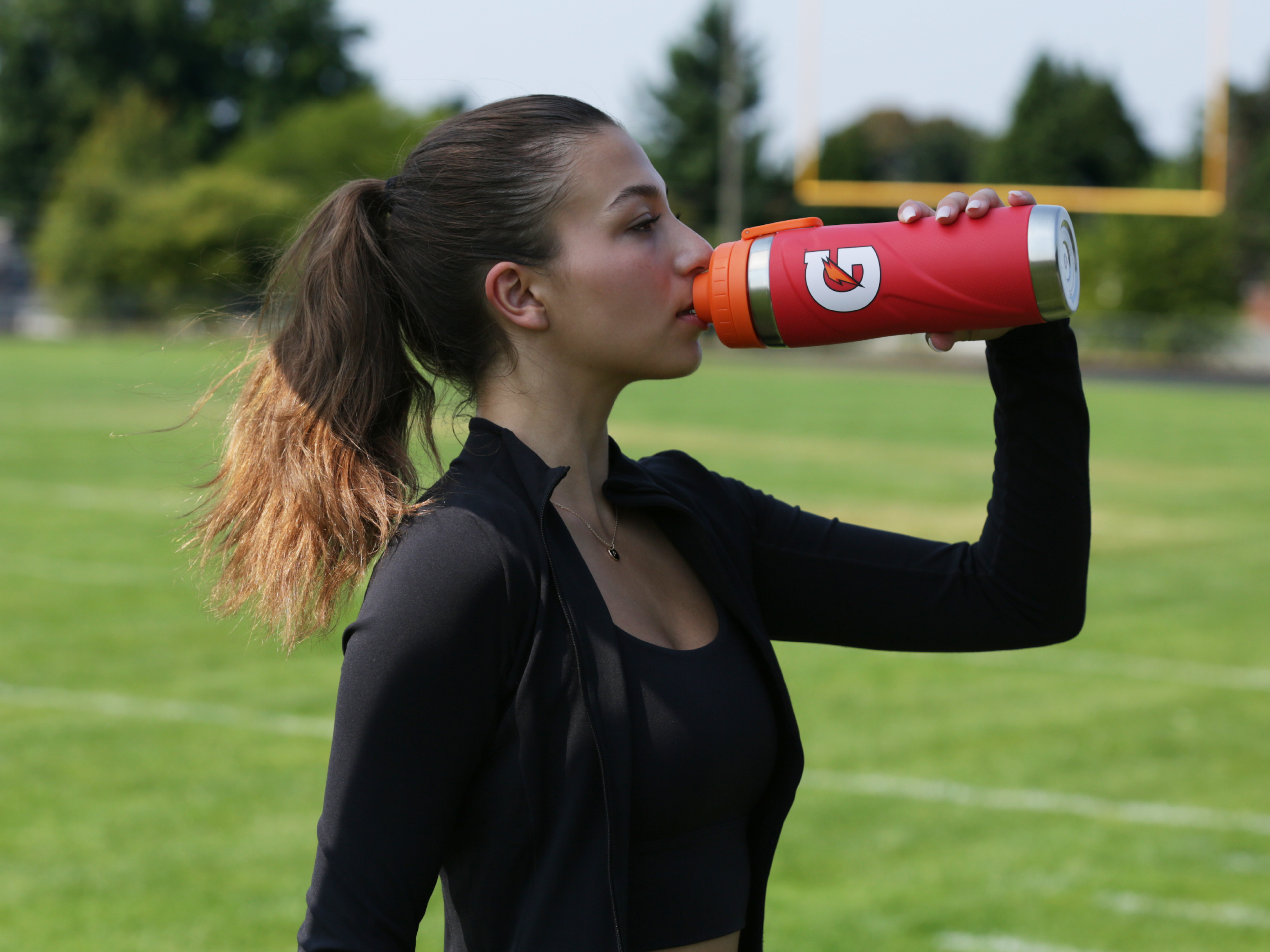 Athlete drinking from a Red Gx Stainless Steel Bottle