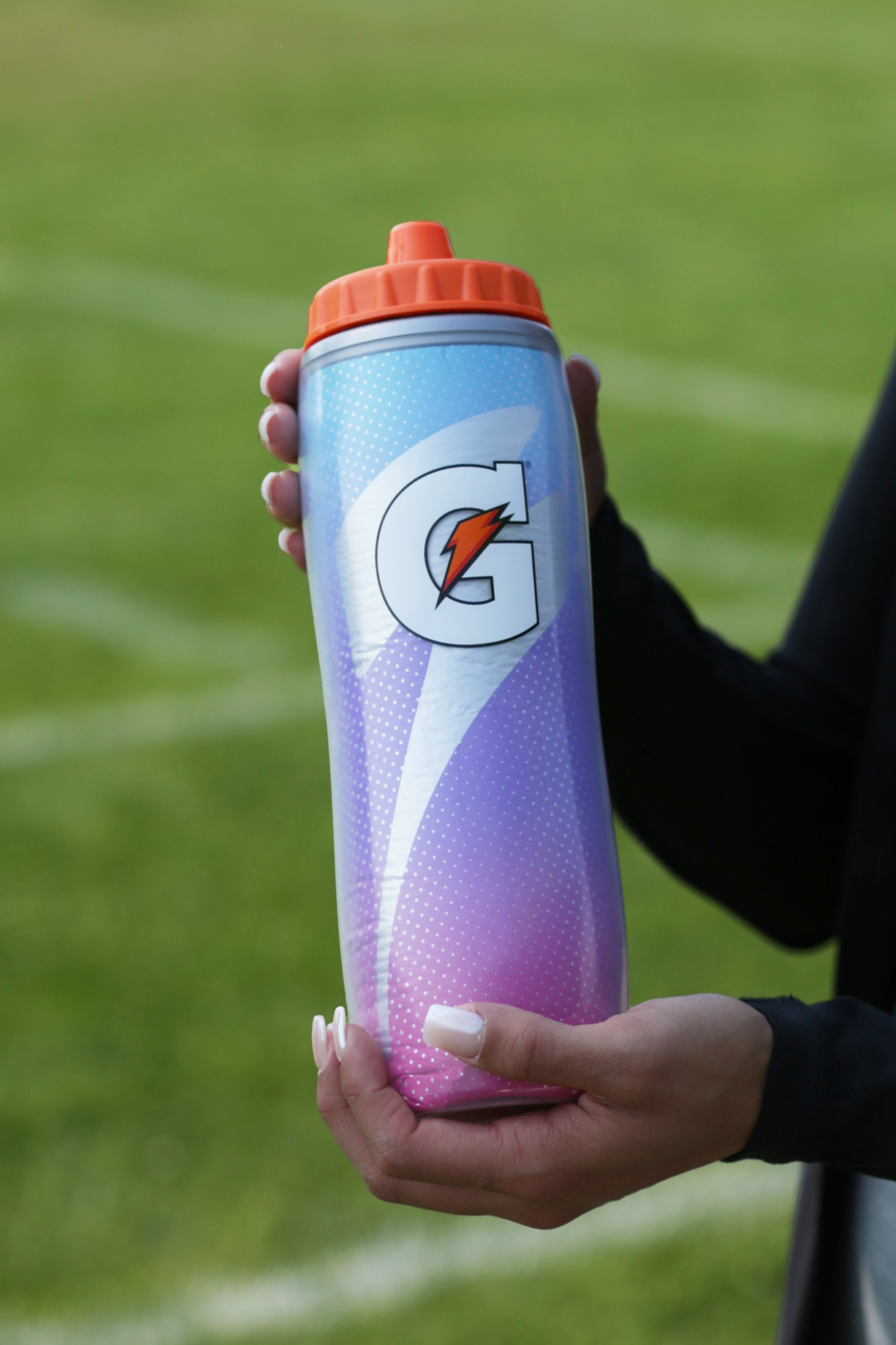 Athlete holding a Pink Sky Insulated Squeeze Bottle