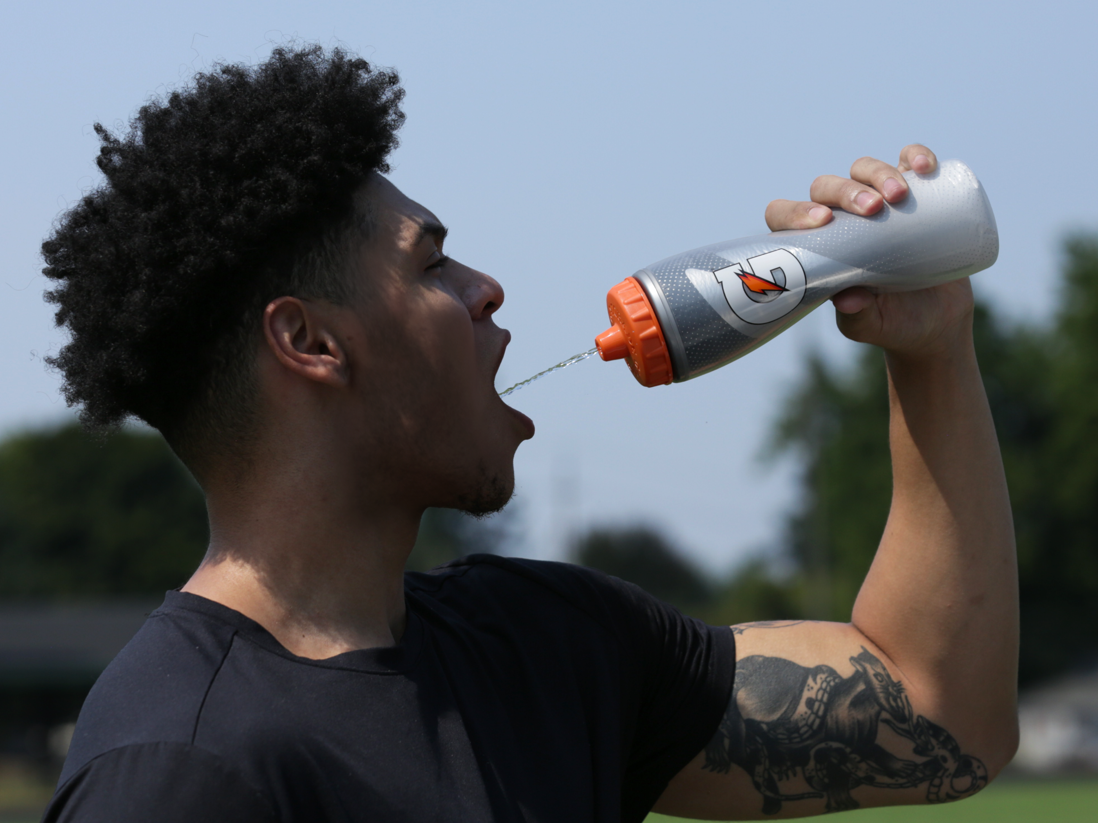 Athlete drinking Gatorade from a Light Shadow Insulated Squeeze Bottle