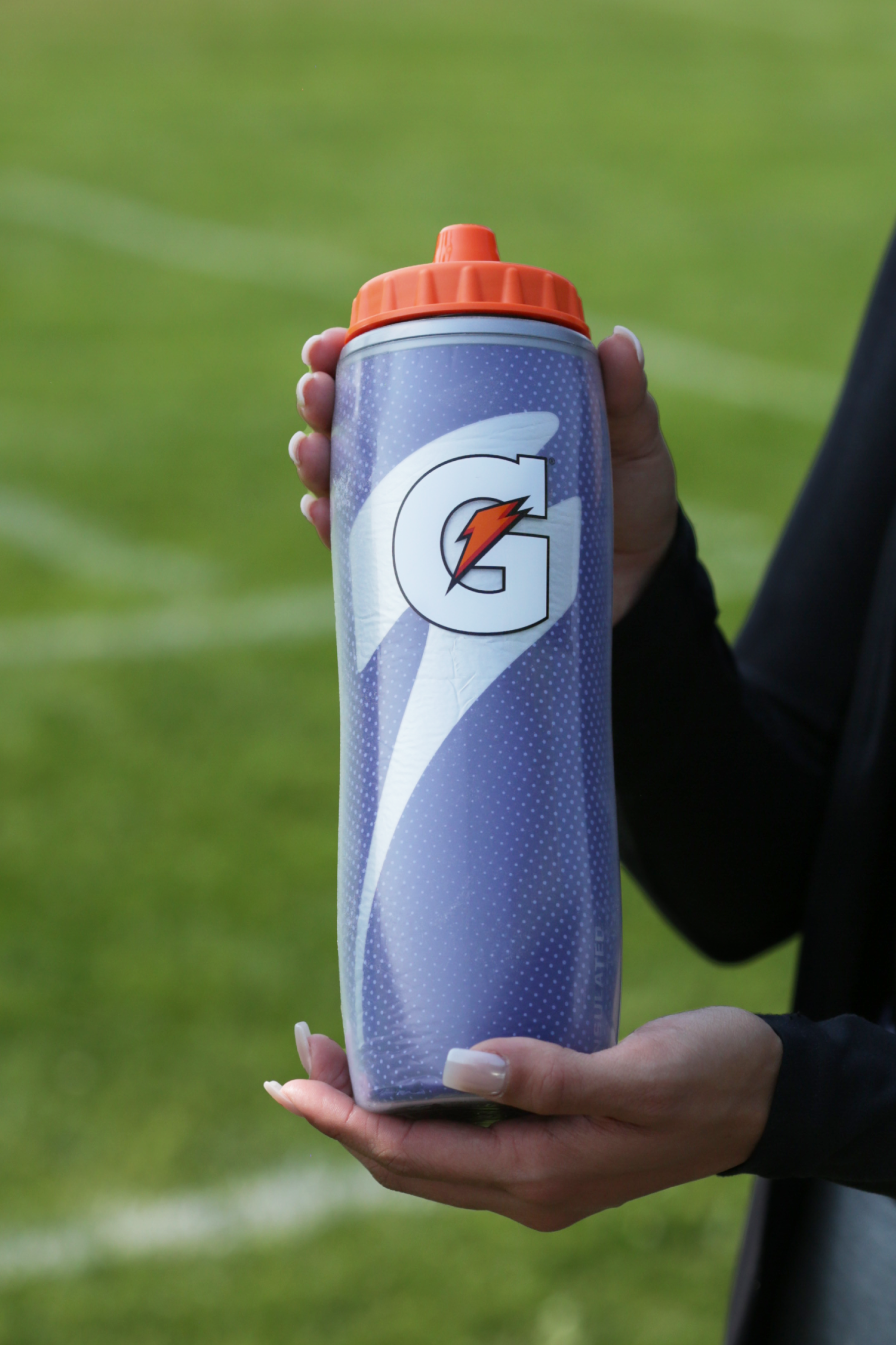 Athlete holding a Purple Insulated Squeeze Bottle