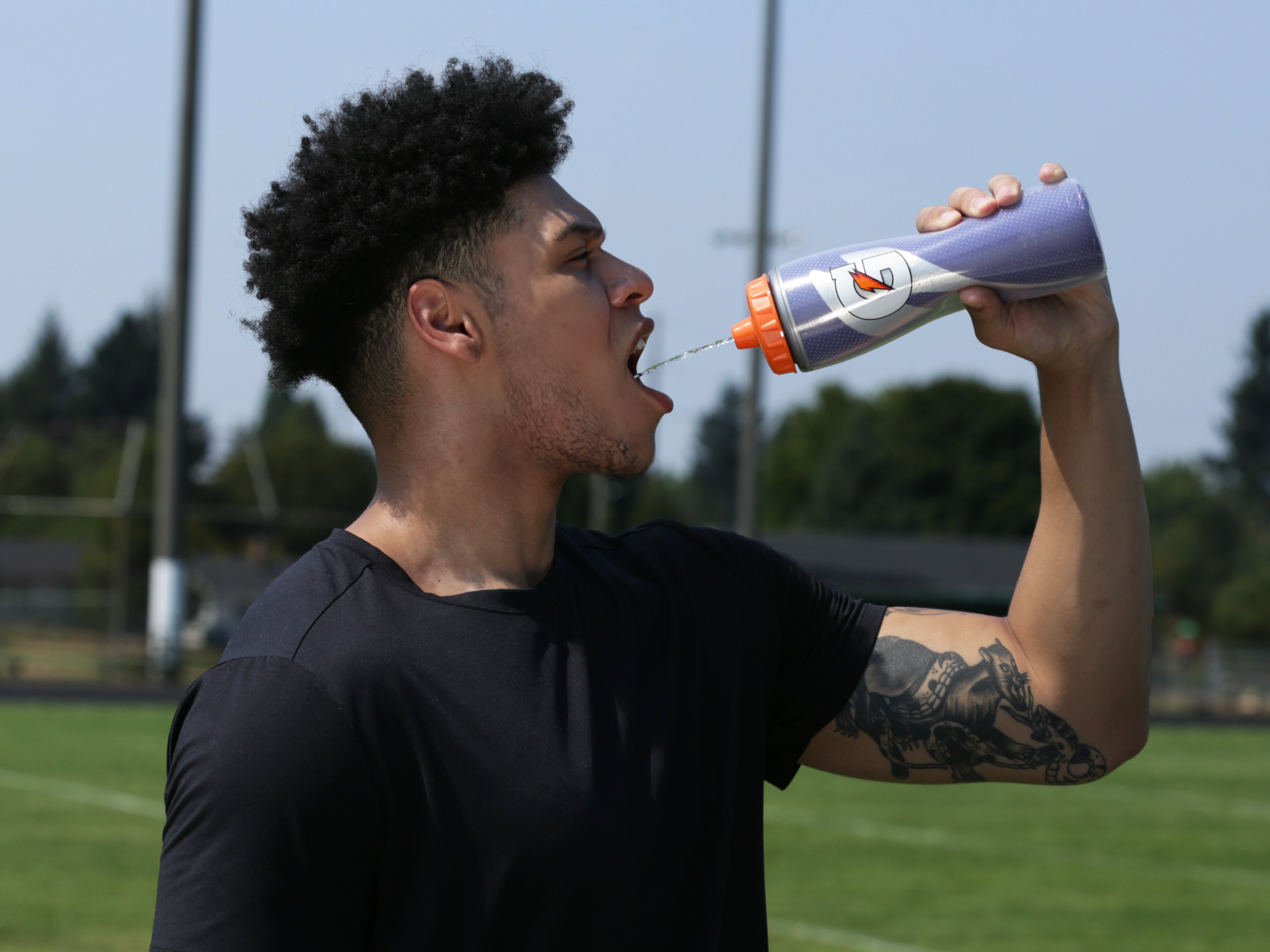 Athlete drinking Gatorade from a Purple Insulated Squeeze Bottle