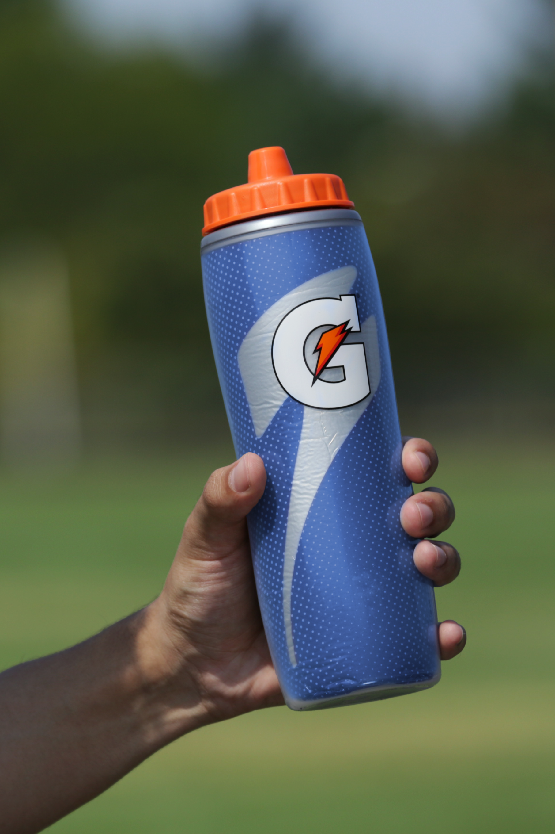 Athlete holding a Royal Blue Insulated Squeeze Bottle