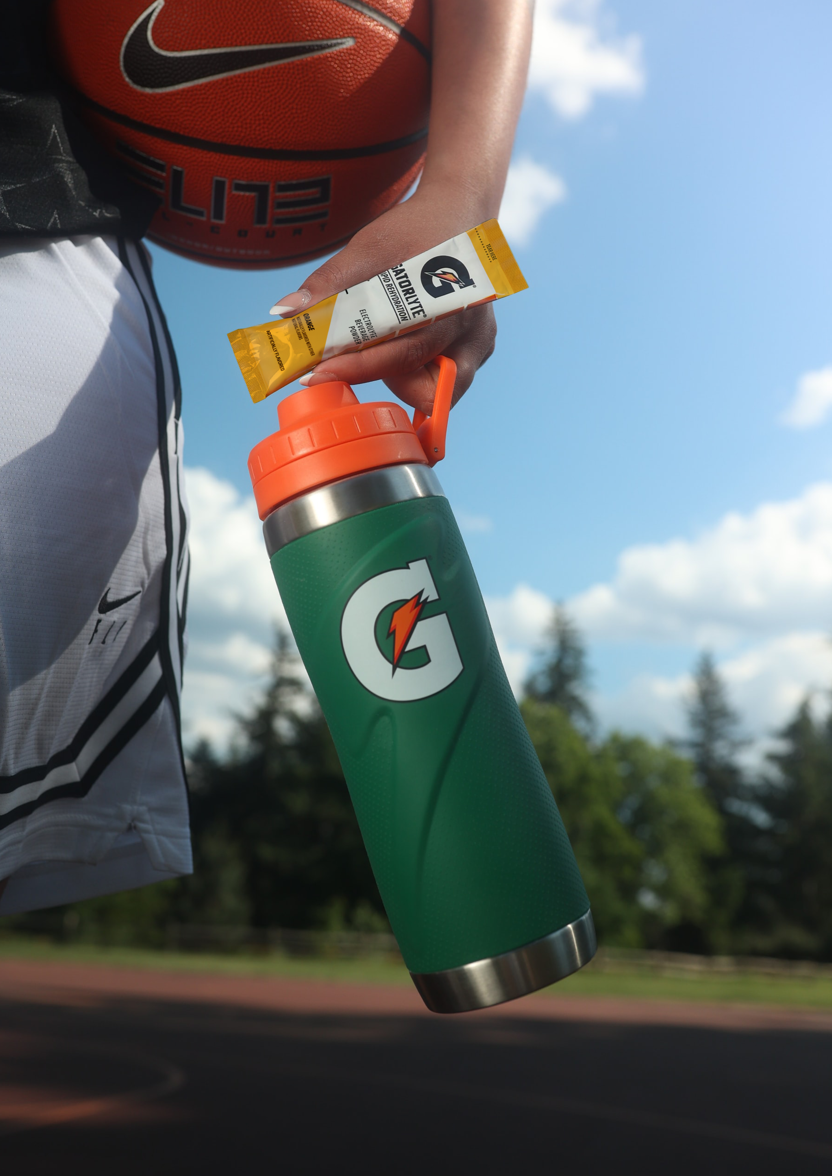 Athlete carrying a basketball, Gatorade Zero Powder packet and Gx Stainless Steel Bottle