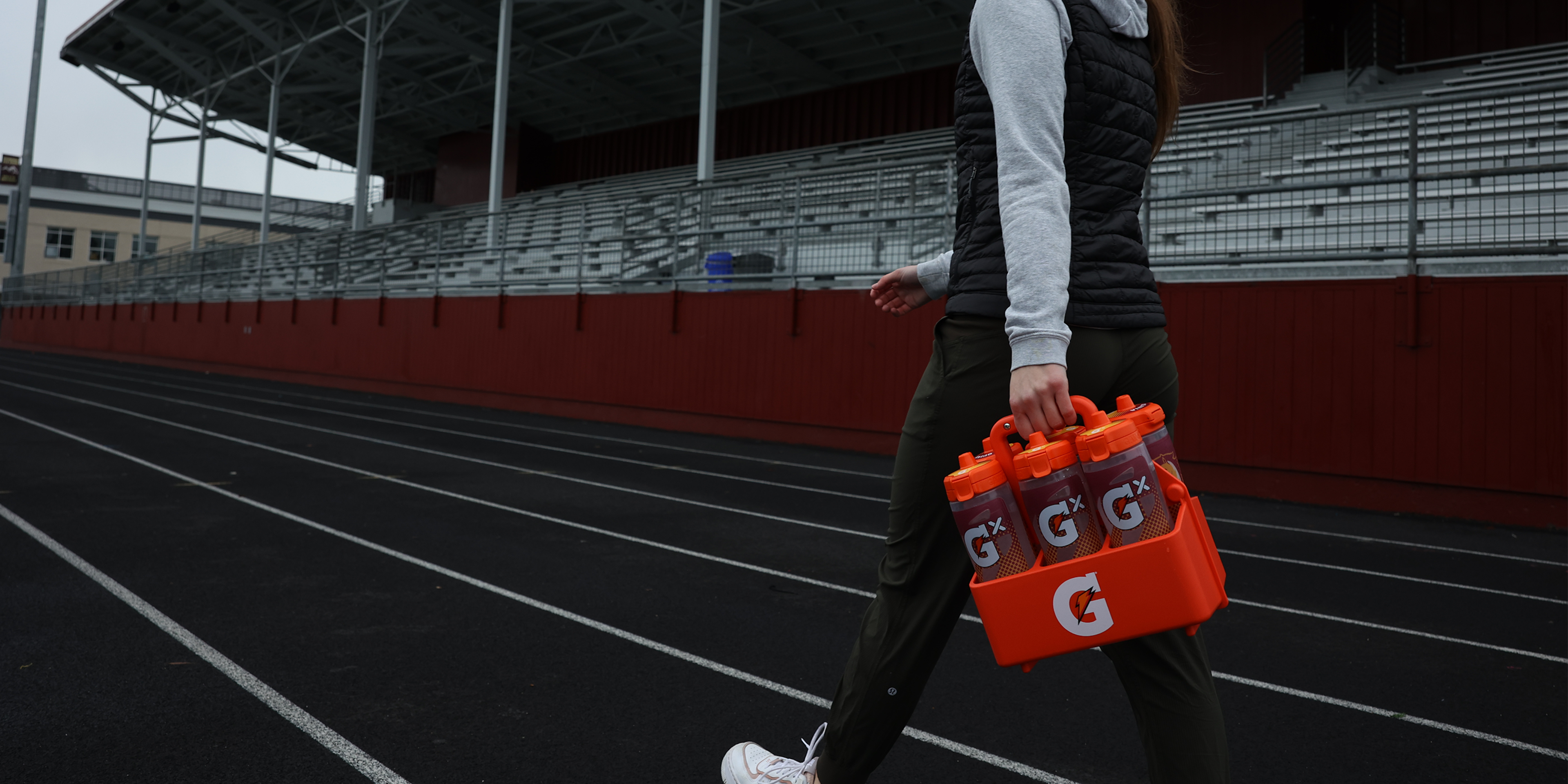 Athlete carrying six G iD customizable squeeze bottles in a Gatorade carrier.