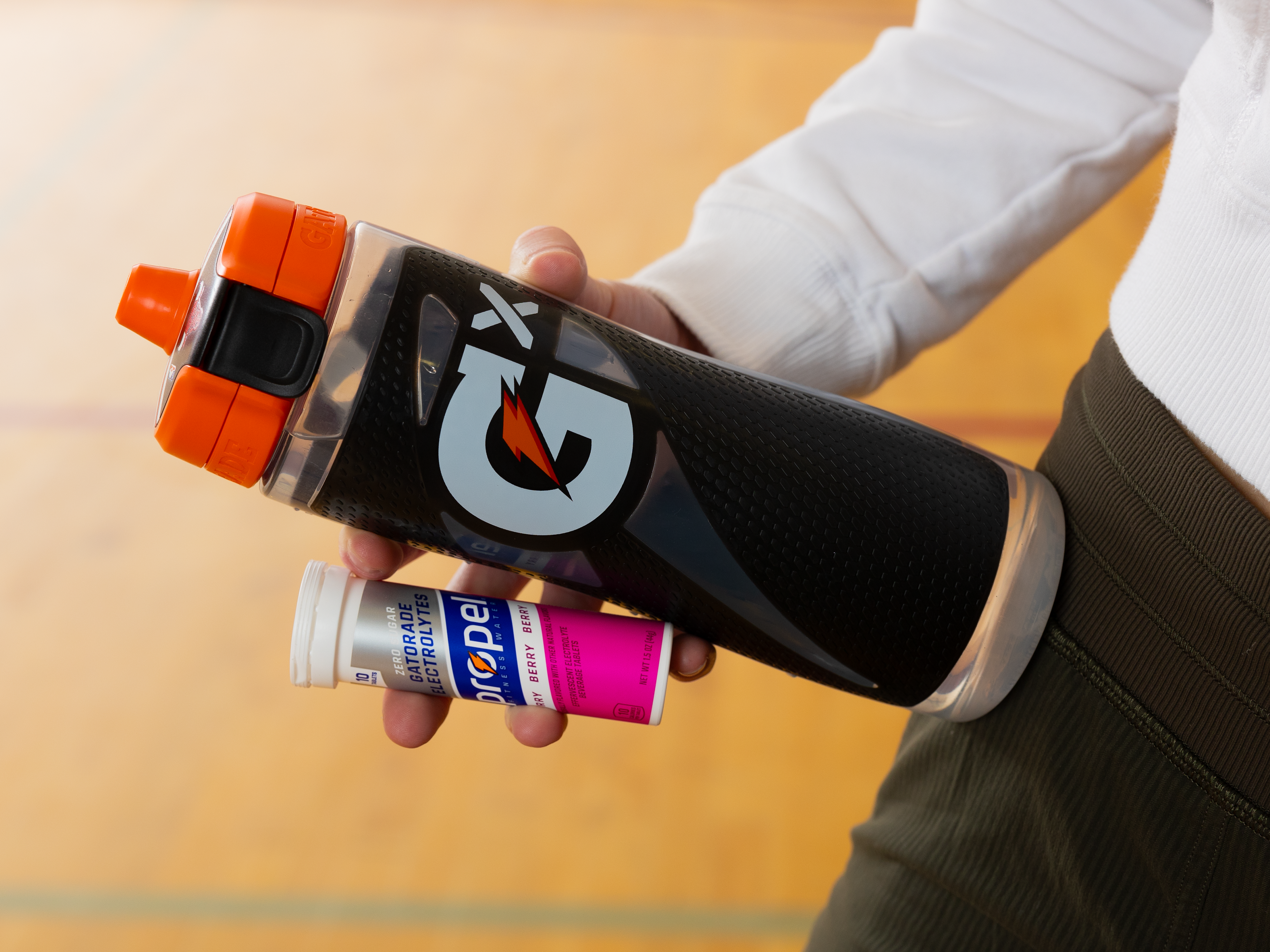 Athlete holding Propel Tablet Berry pack with a Gx Squeeze bottle.